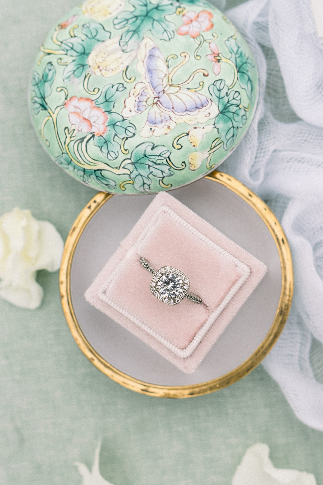 Artistic shot by Tiffany Longeway of wedding rings amidst elegant floral arrangements at Sunstone Winery, Southern Calif
