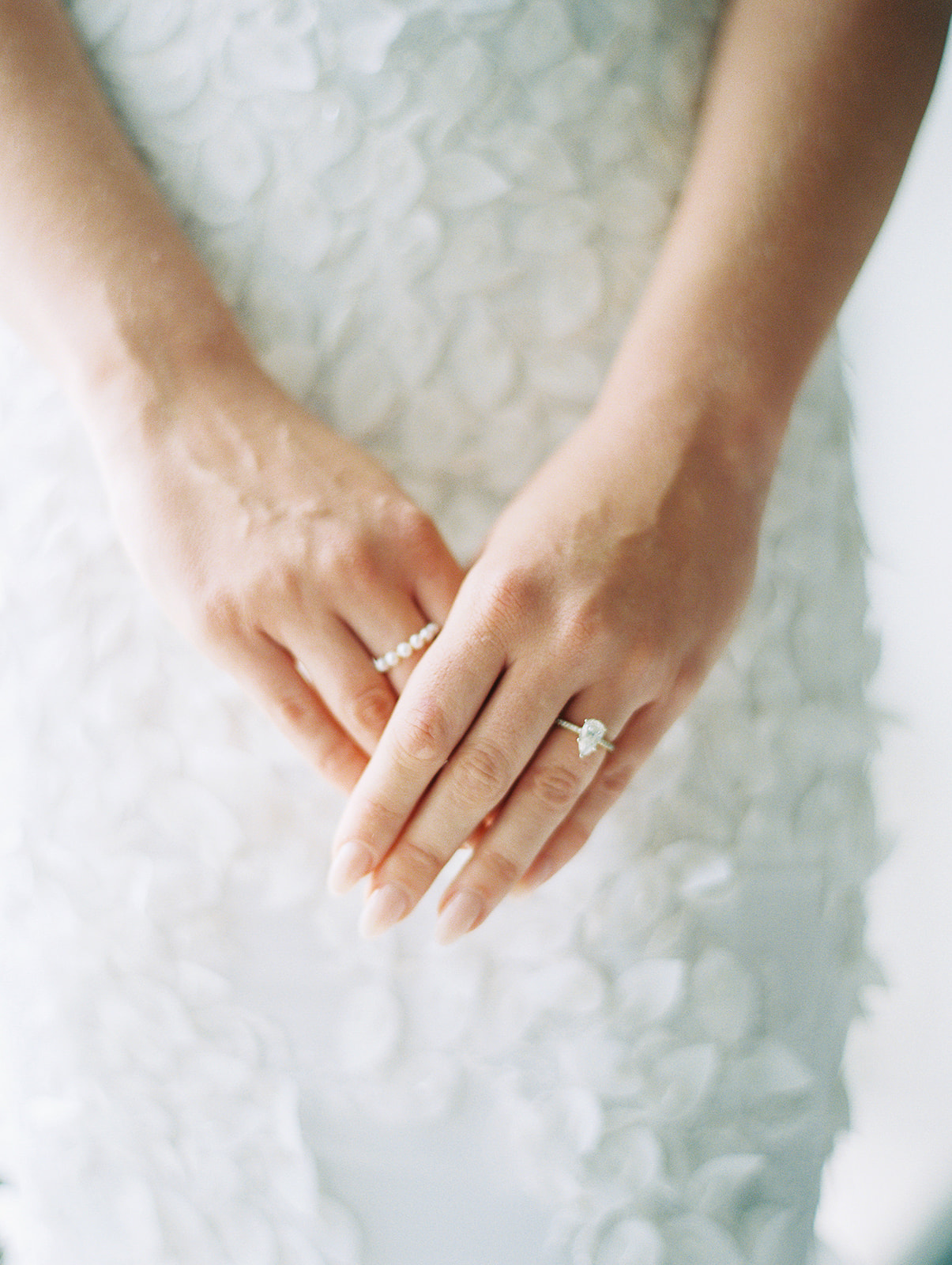 Bride's hands folded with an engagement ring