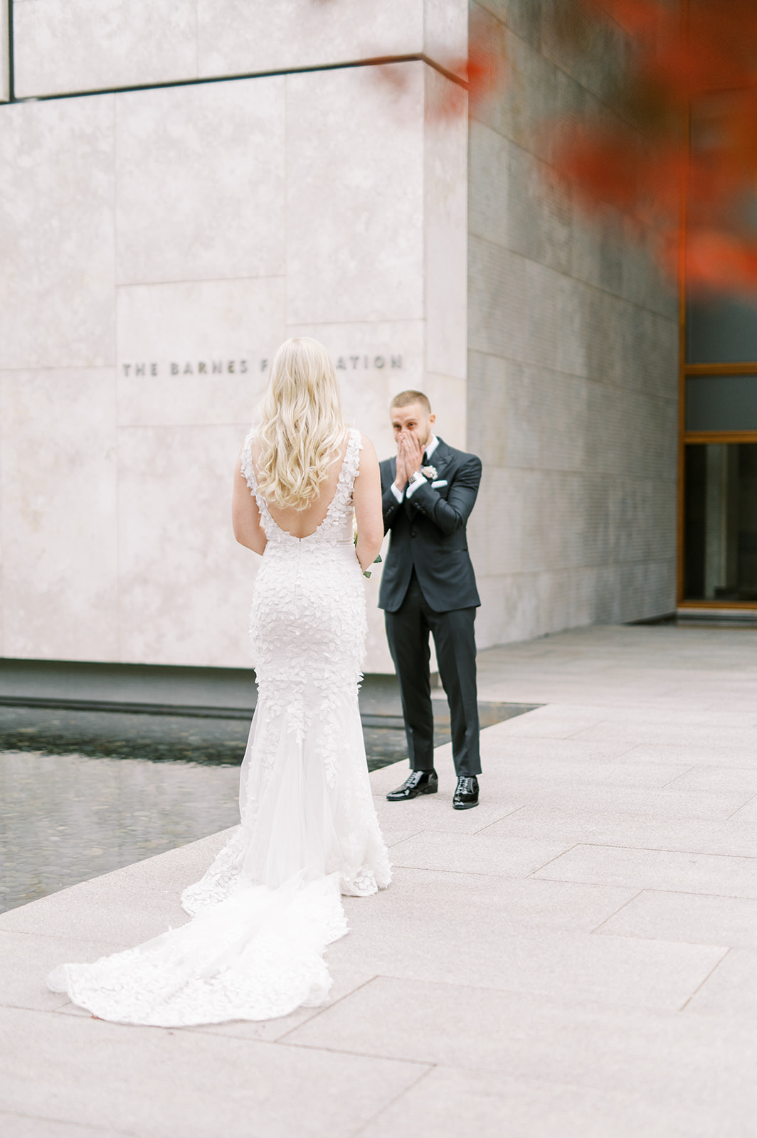 Groom surprised after seeing his bride for the first time at the Barnes Foundation reflecting pool