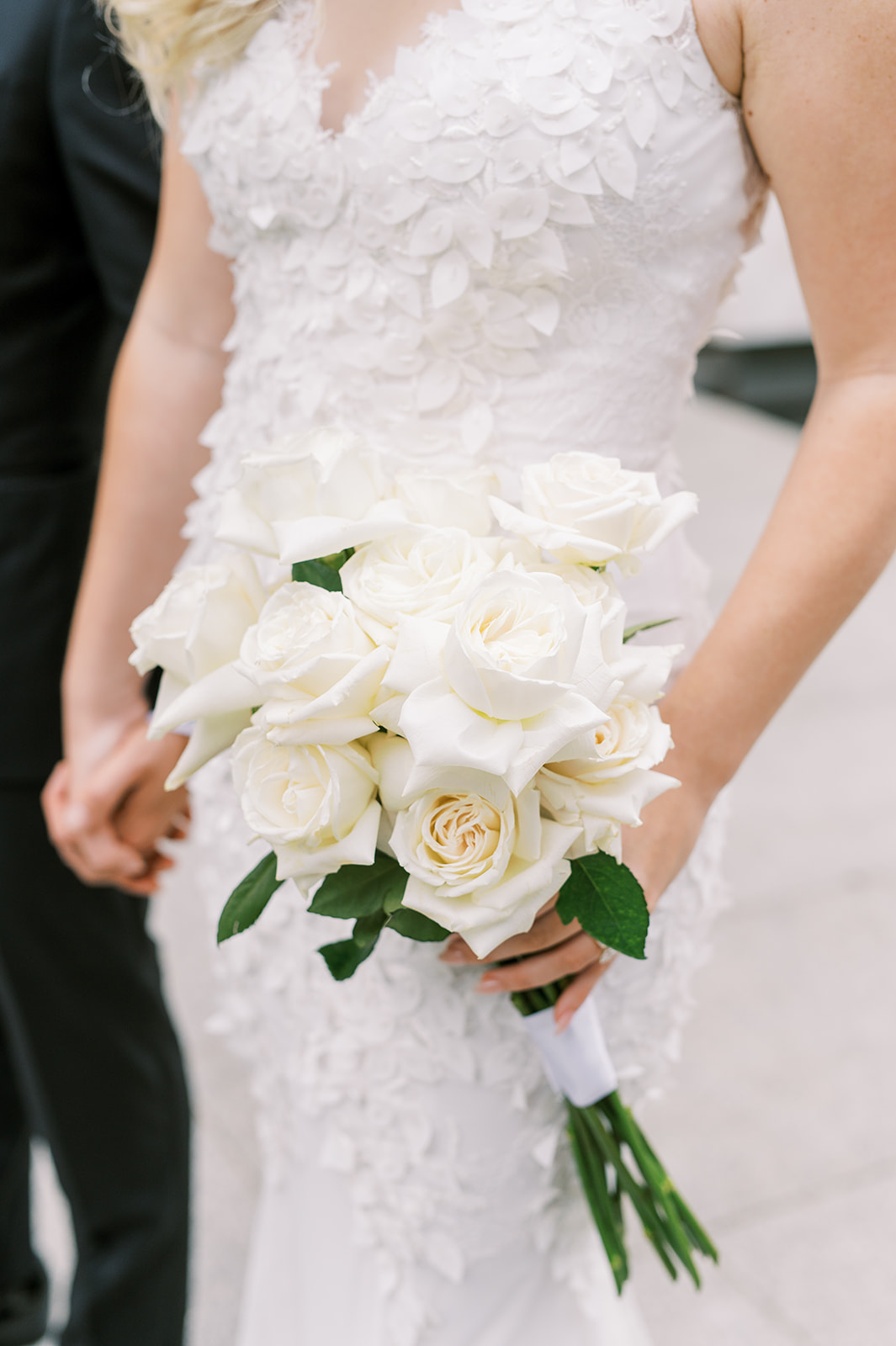 Bride holding bouquet of white long-stem roses