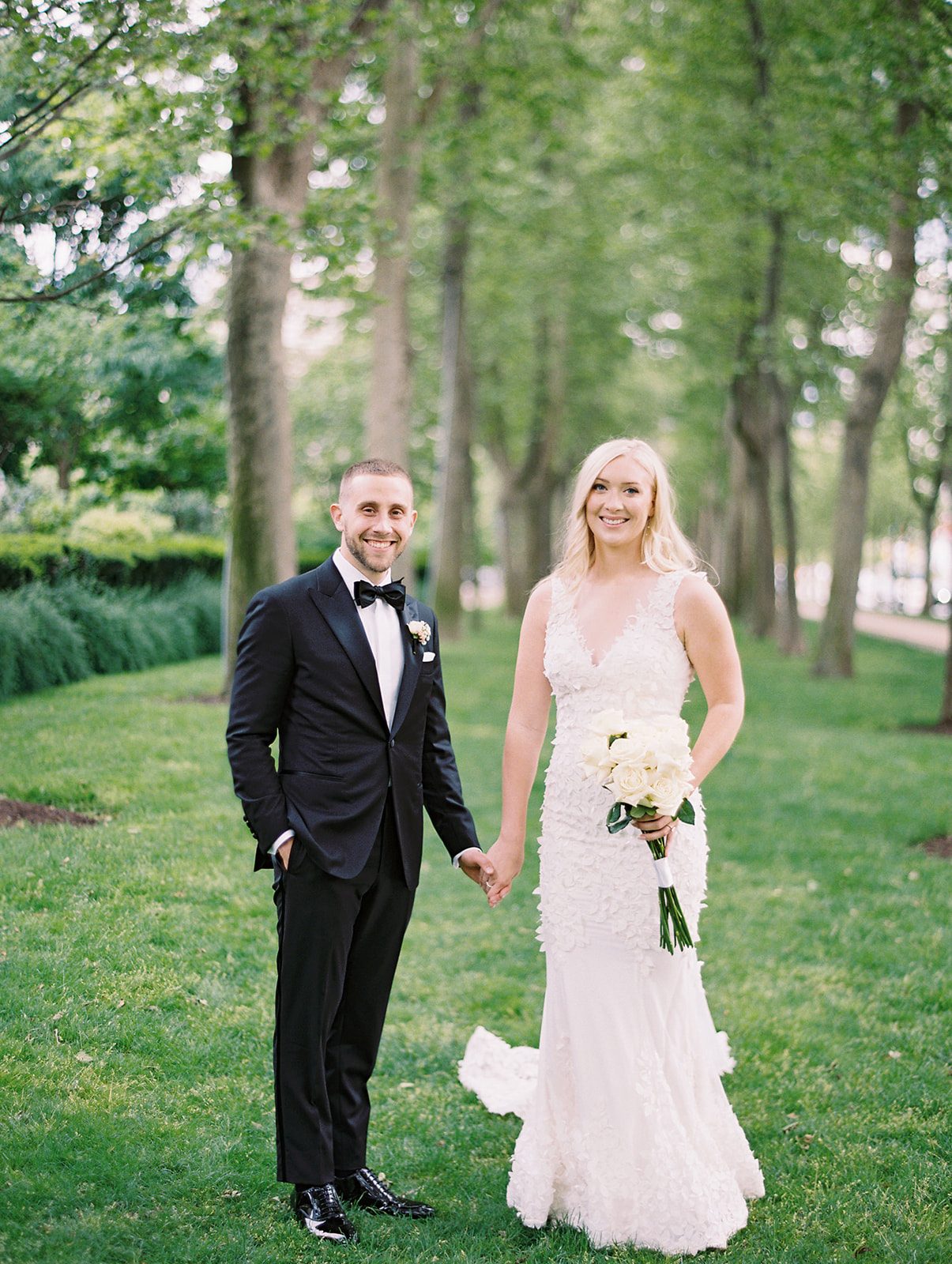 Bride and Groom holding hands and smiling at the camera at the Barnes Foundation