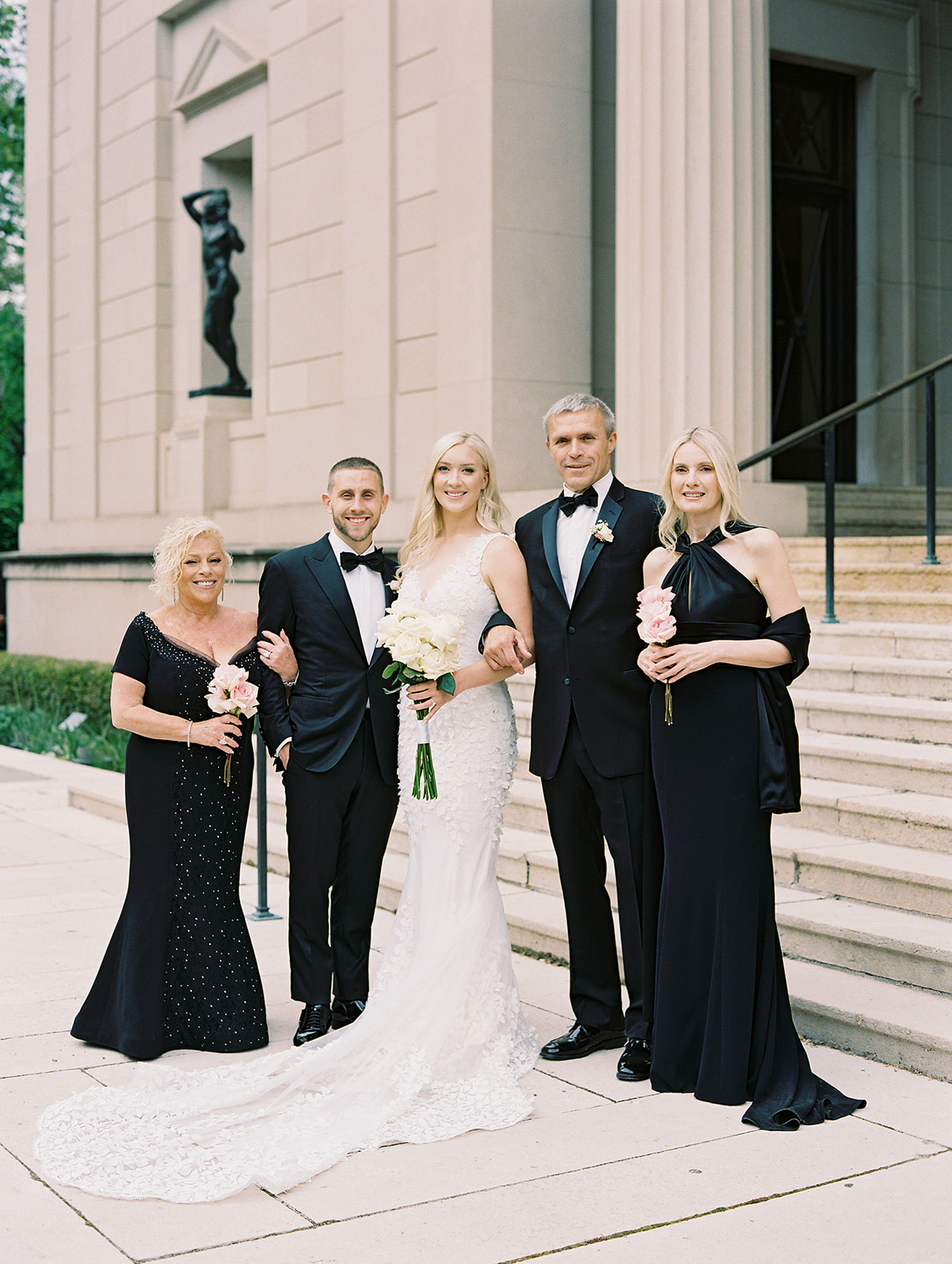 Family Portraits of a bride and groom and their parents wearing black