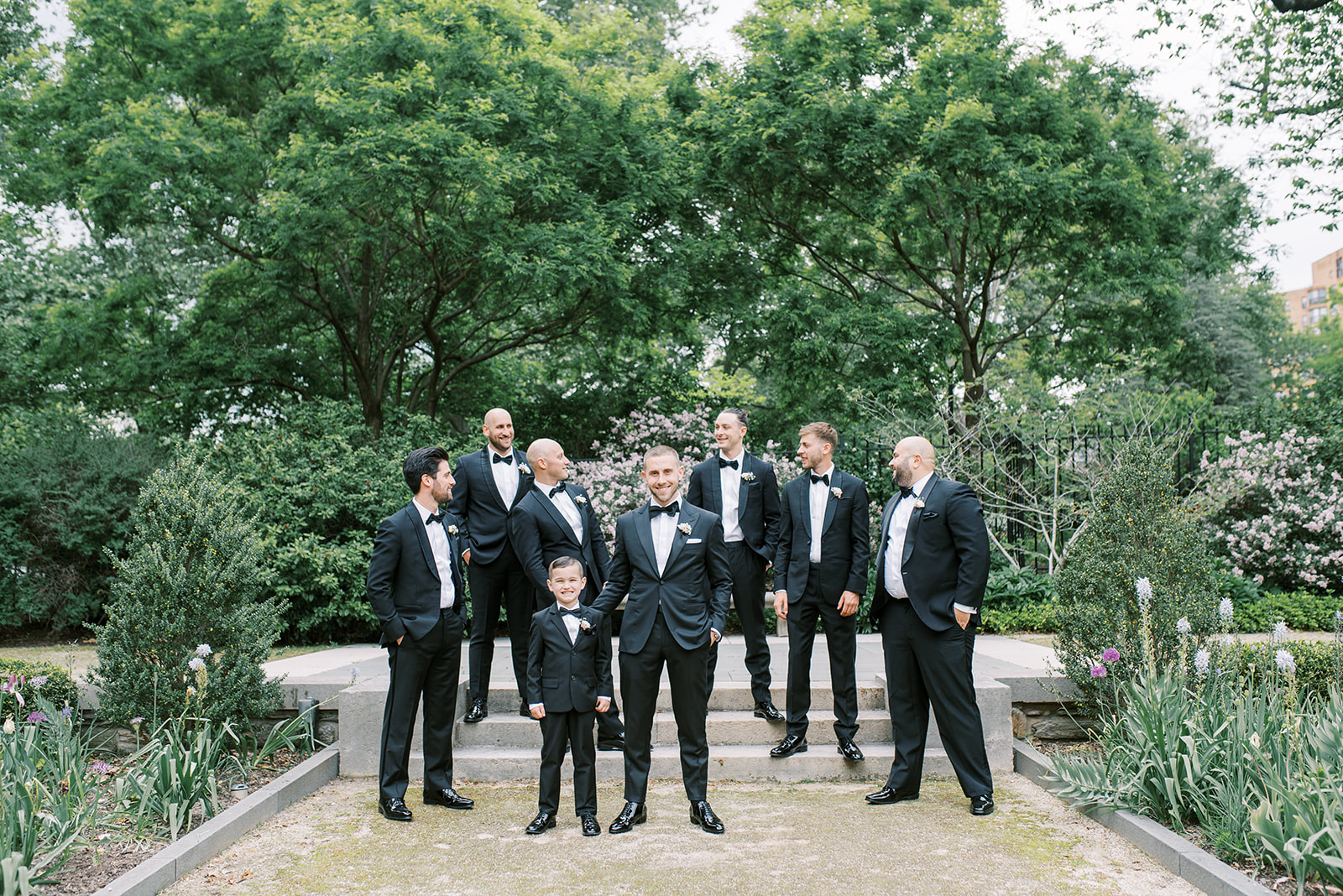 a groomsmen and his attendants all in black tuxes at the Rodin Museum