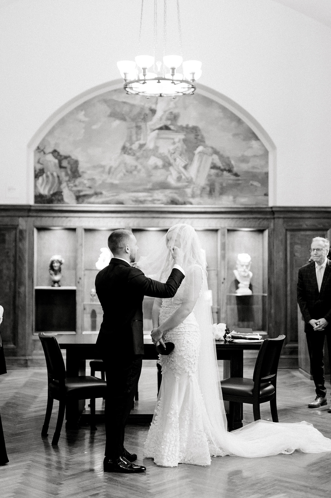 black and white photo of groom lifting bride's veil during ketubah signing at the Rodin Museum