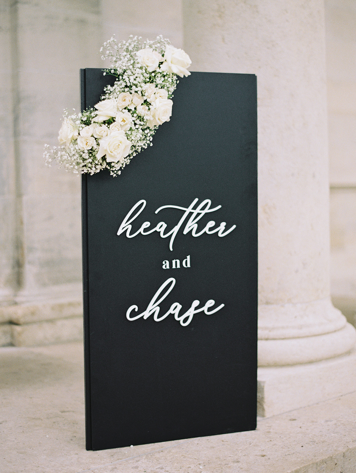 Black welcome sign for Heather and Chase's wedding at the Rodin Museum with an accent of white roses and babies breath