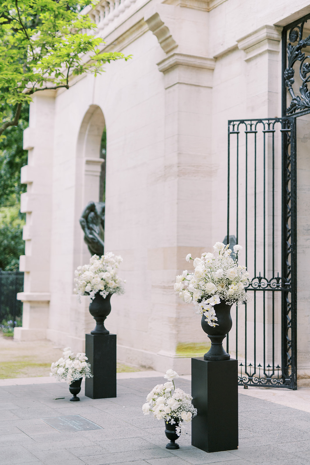 ceremony floral setup at Rodin Museum with black urns and pedestals and white florals