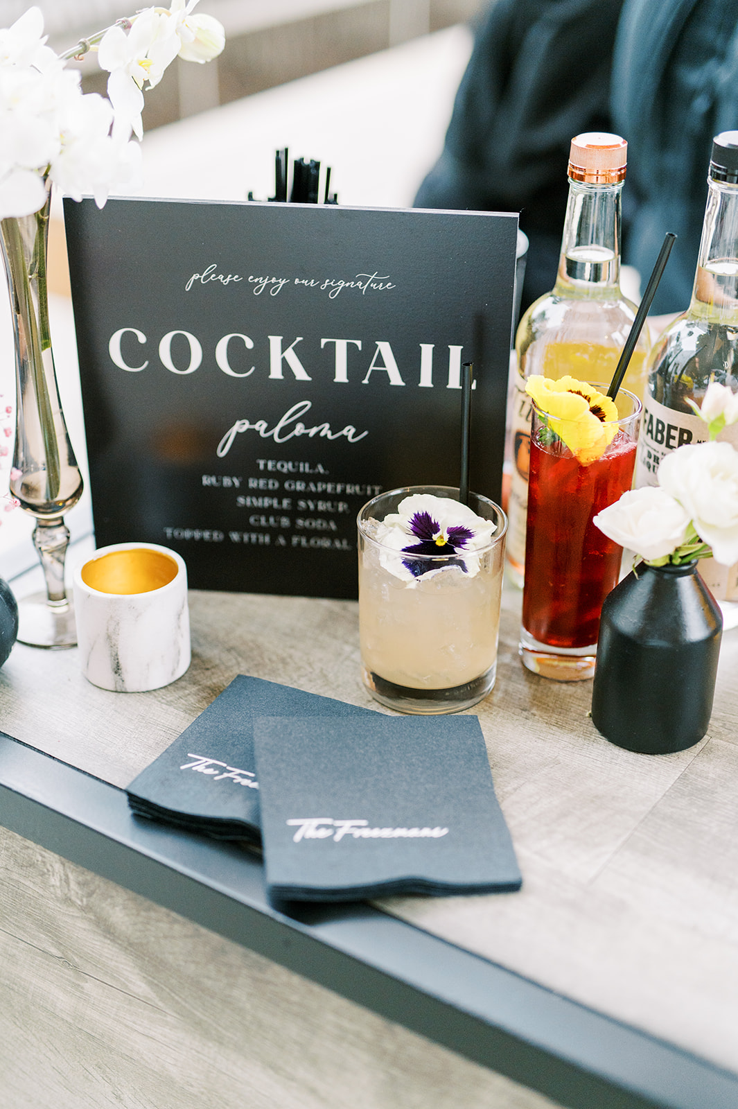 Black cocktail bar sign with custom black napkins and signature cocktails