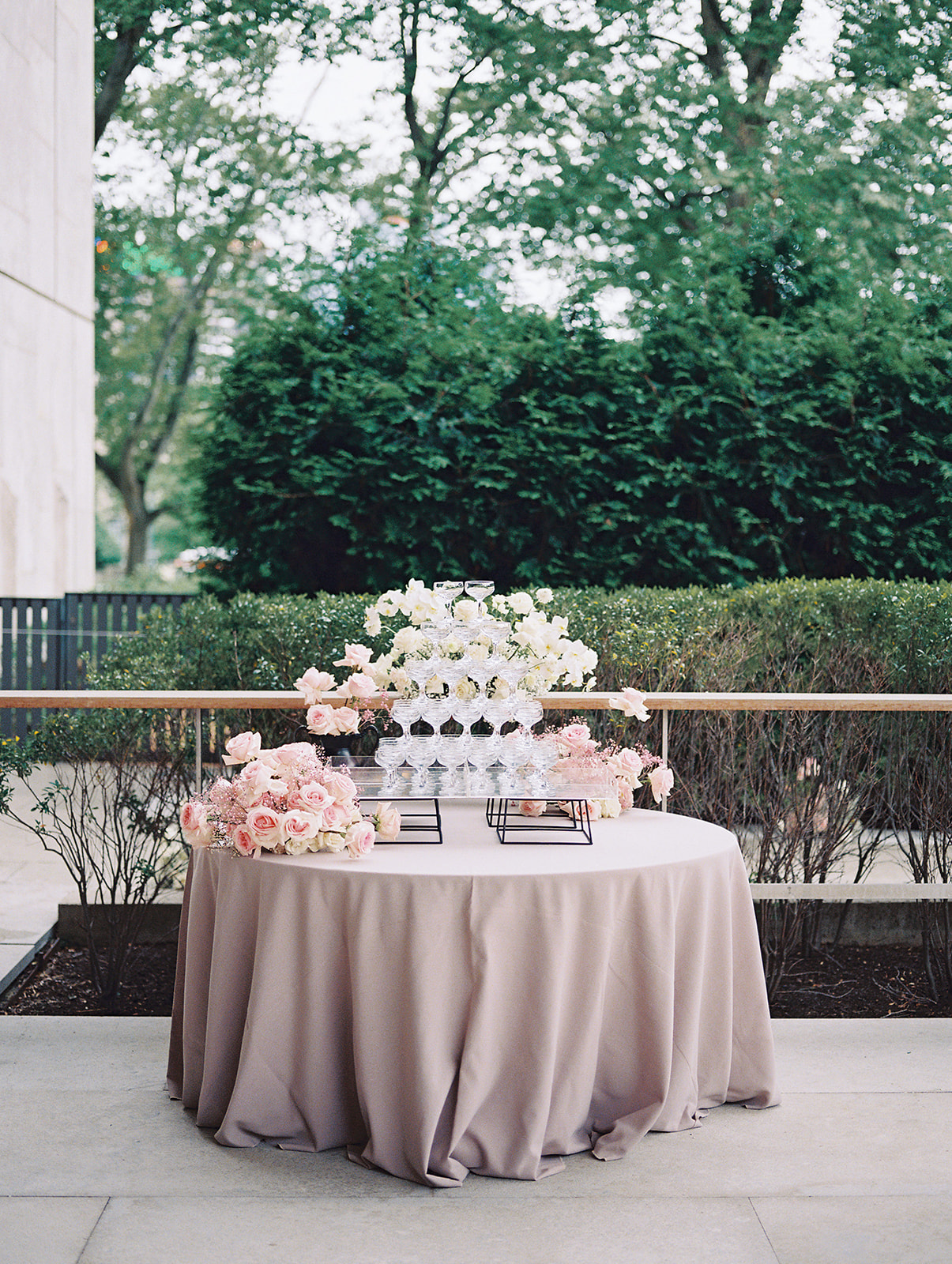 table with gray linen and champagne glasses in pyramid outdoors at Barnes Foundation wedding cocktail hour