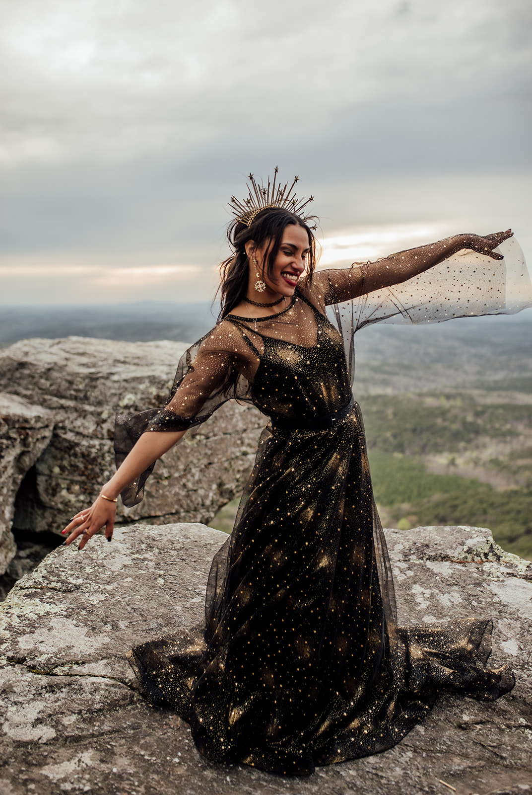 bride with black and gold dress with a gold crown on Mt. Cheaha