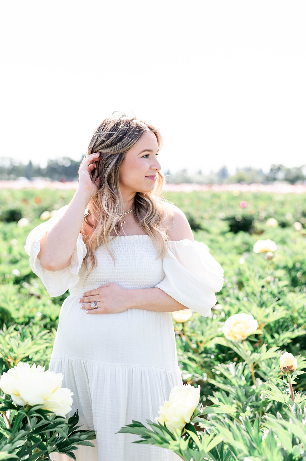 mama-to-be in a field of yellow peony flowers