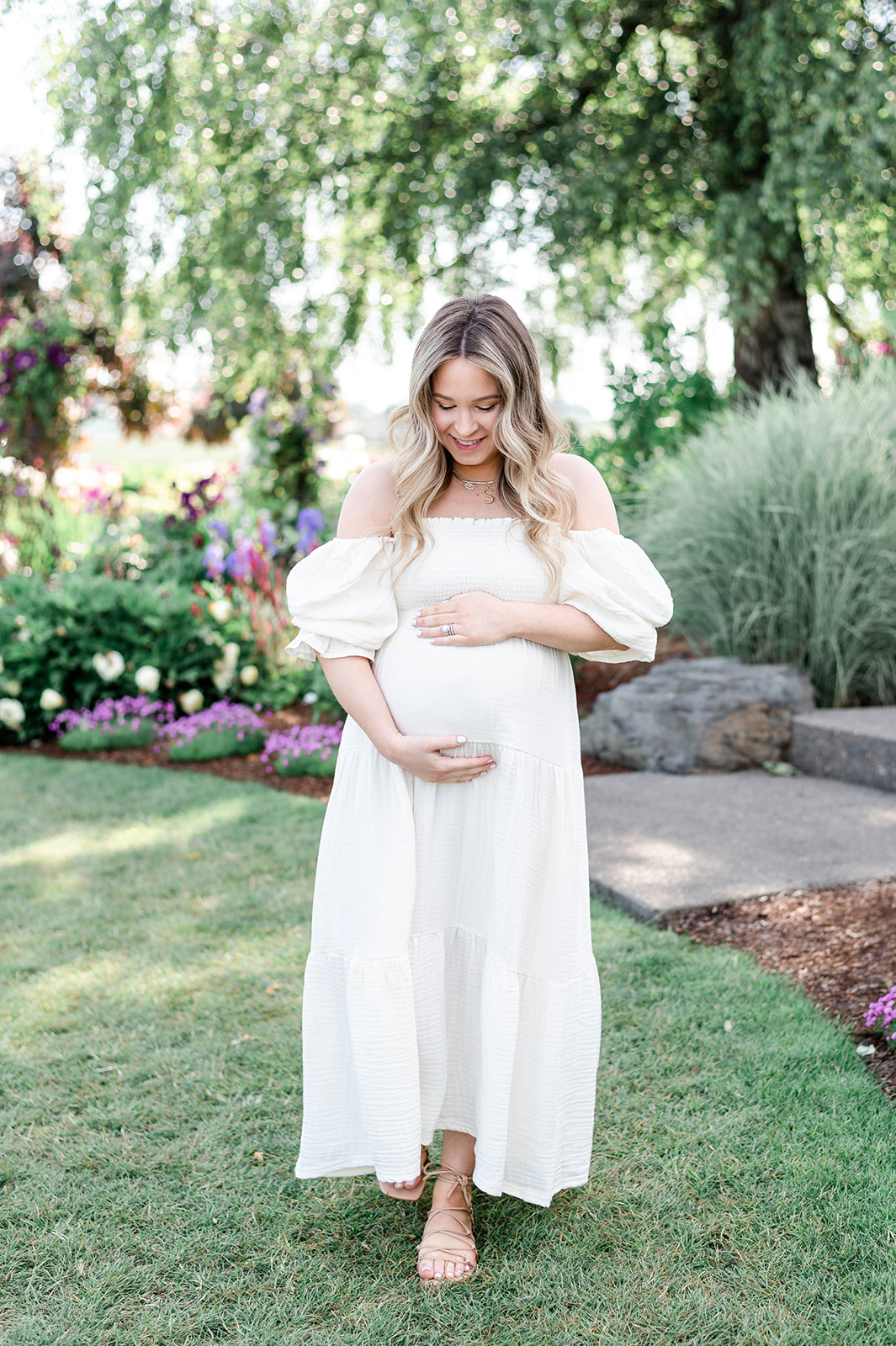 a pregnant woman in a flowing white dress in the Springtime in Oregon