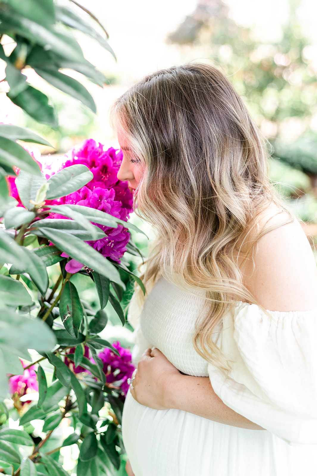 pregnant woman smelling a flower
