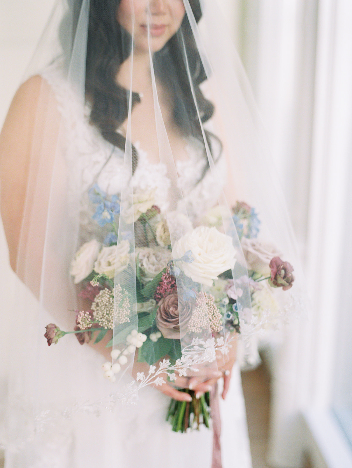 blue and burgundy parisian inspired bouquet under bridal veil