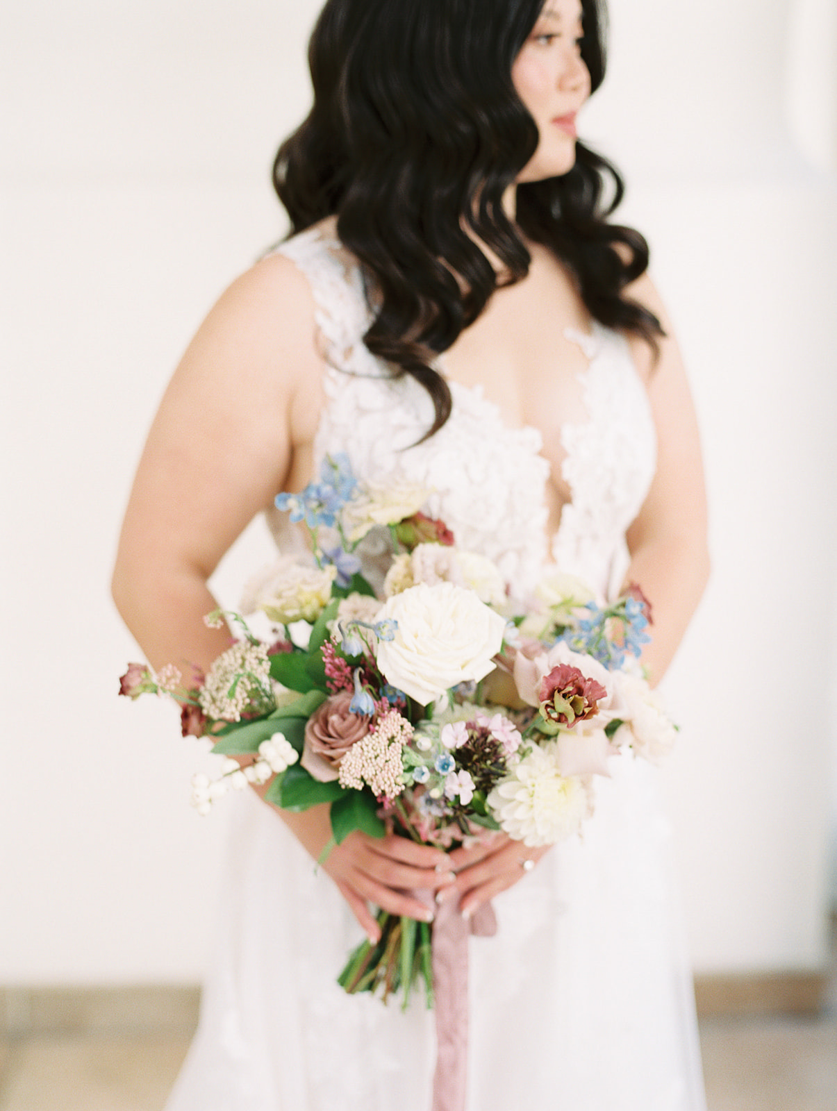parisian inspired floral bouquet with white, french blue, and burgundy held by bride at Pomme in Radnor, Pennsylvania
