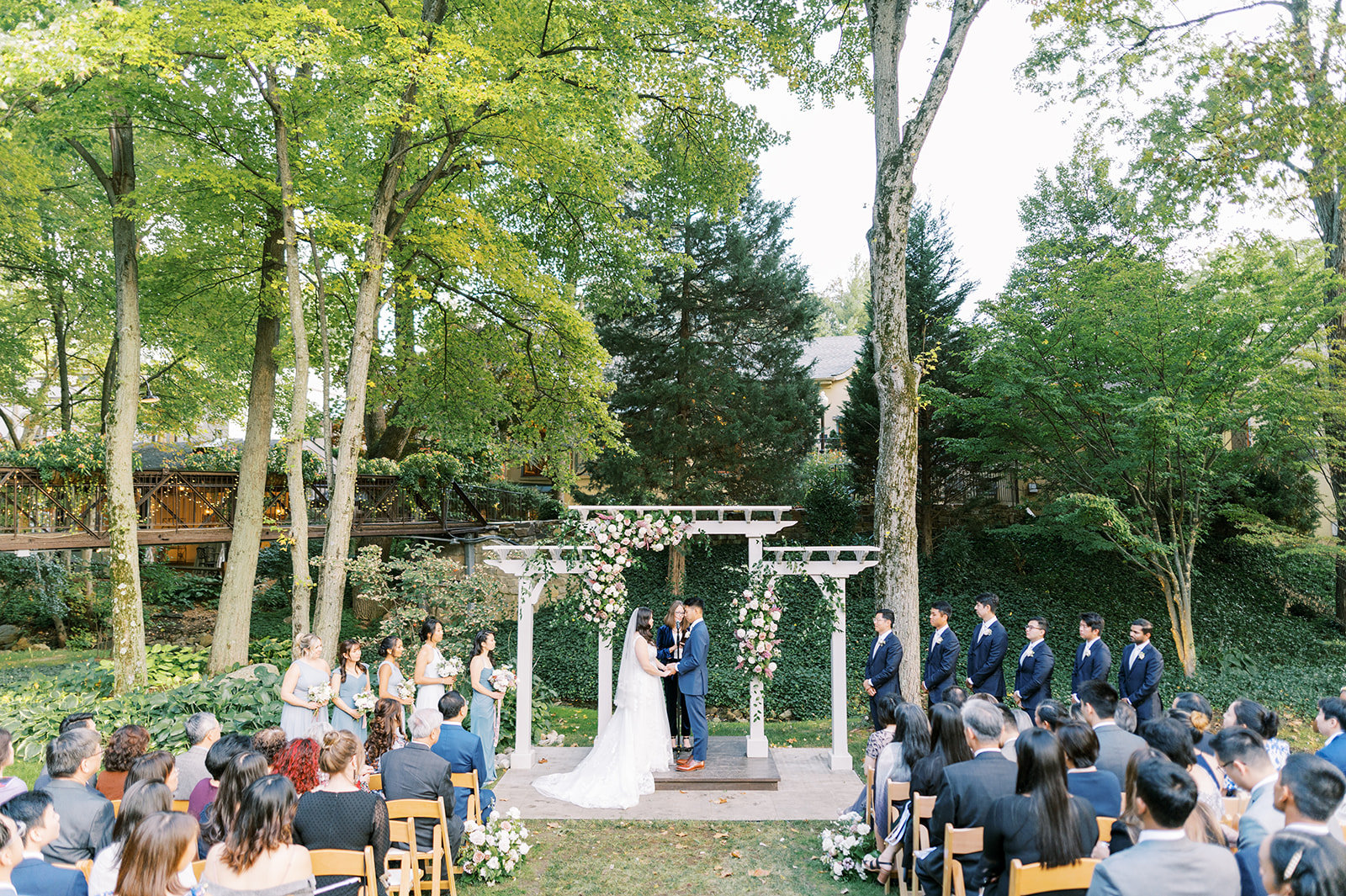 parisian inspired wedding ceremony on the lawn under tall trees at Pomme in Radnor, PA