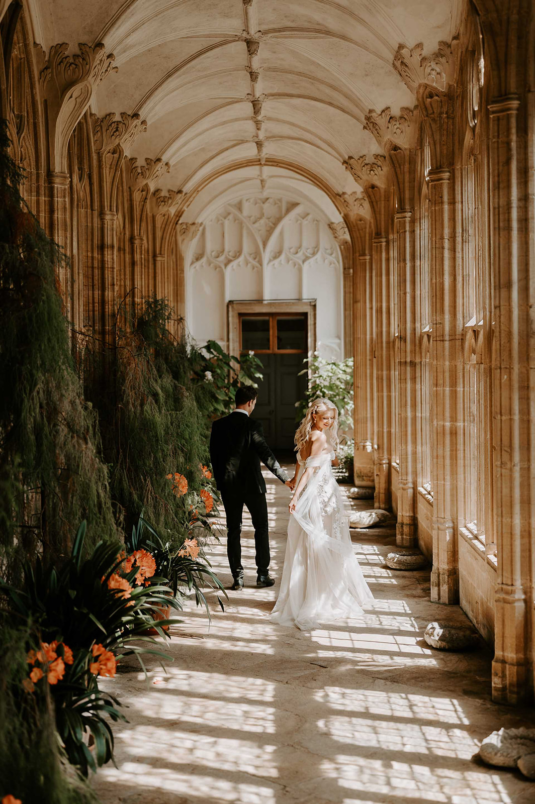 bride and groom walking through orangery at ford abbey