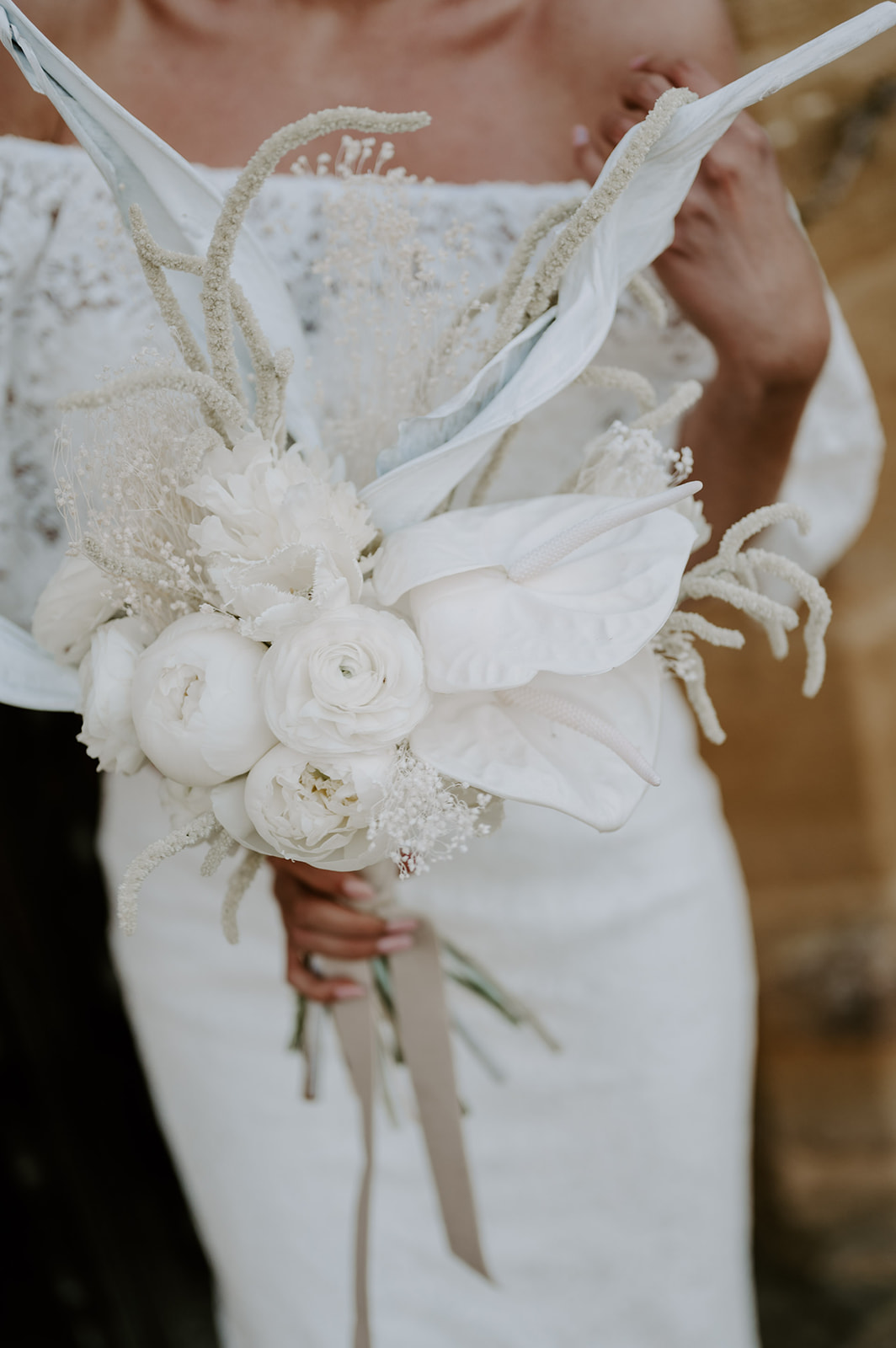bride wearing shikoba dress holding neutral white wedding bouquet
