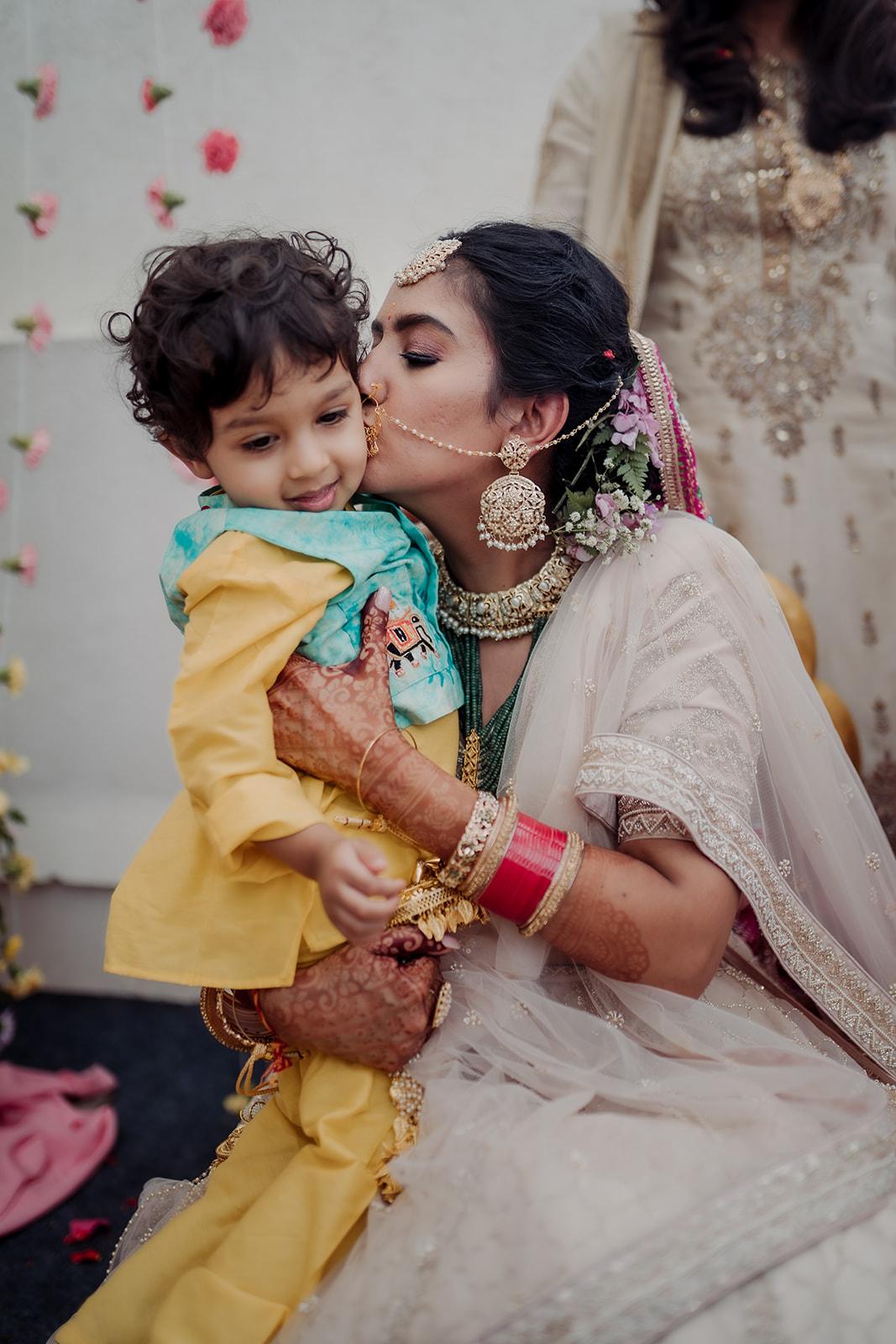 Generational love: Bride bonds with a sweet baby, capturing a moment of familial connection