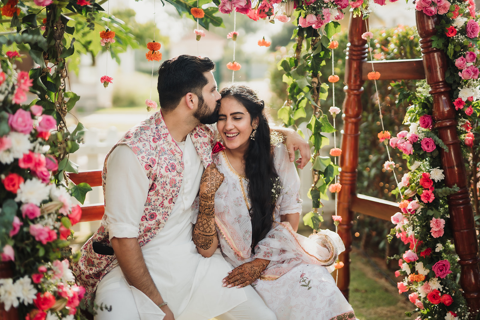 Affectionate kiss: Capturing the groom's loving gesture as he plants a kiss on the bride's forehead