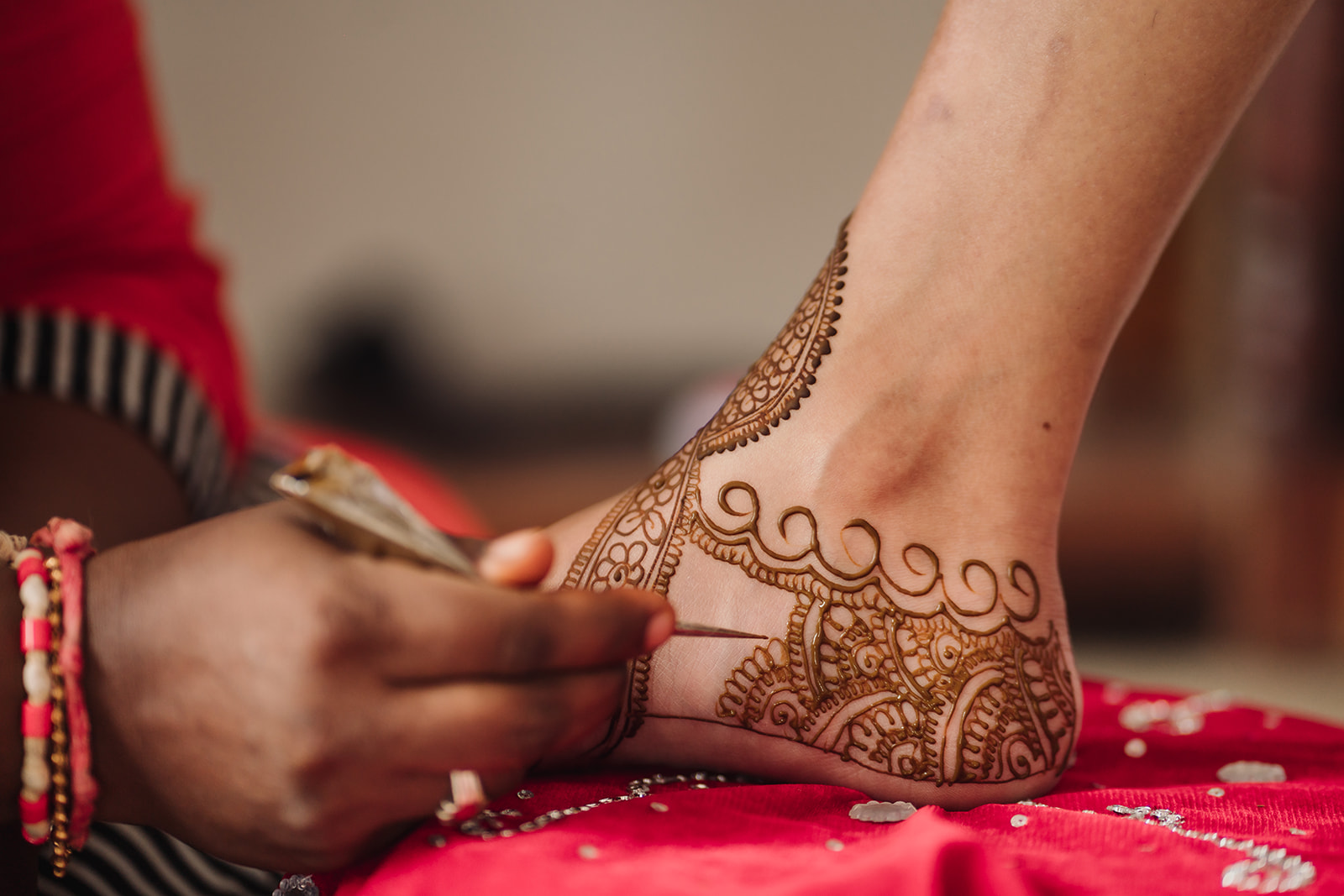 Mehendi magic: The bride experiences the beauty of mehendi application in this captivating image