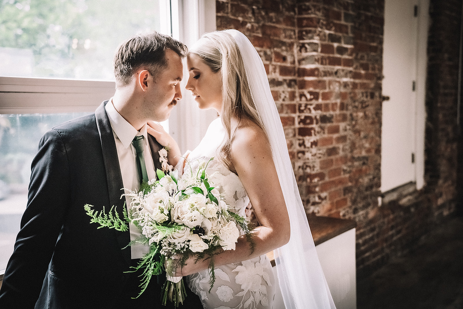 wedding photography in window with brick wall in background Brightside Music & Event Venue Dayton, Ohio