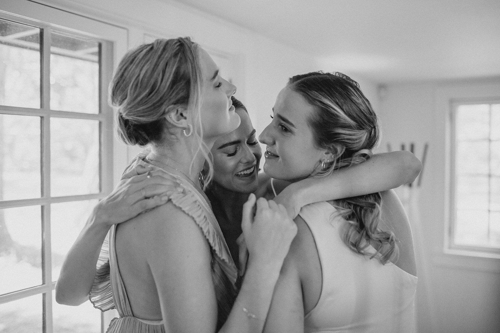 Bride has an emotional moment with her sisters as they see her in her dress at Camp Wandawega's Hillhouse
