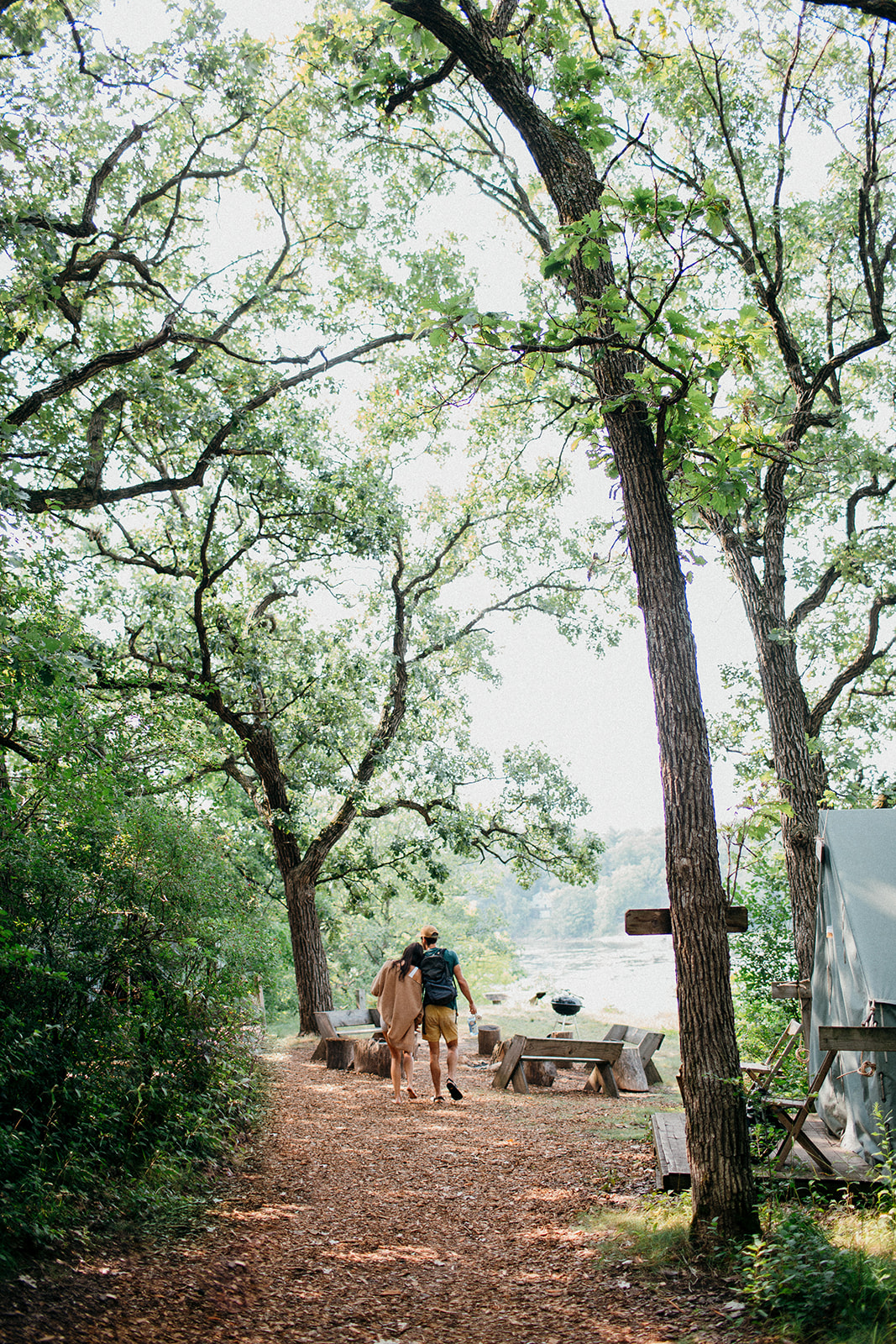 Couple walks down a treelined path at Camp Wandawega