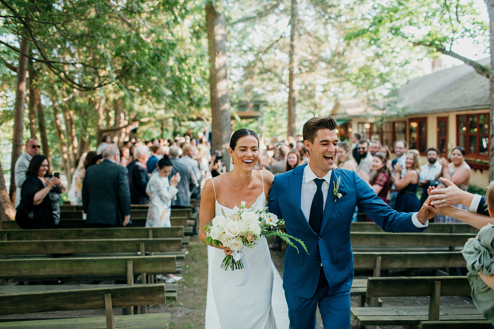 Wedding couple celebrates during their processional down the aisle at the chapel of Camp Wandawega