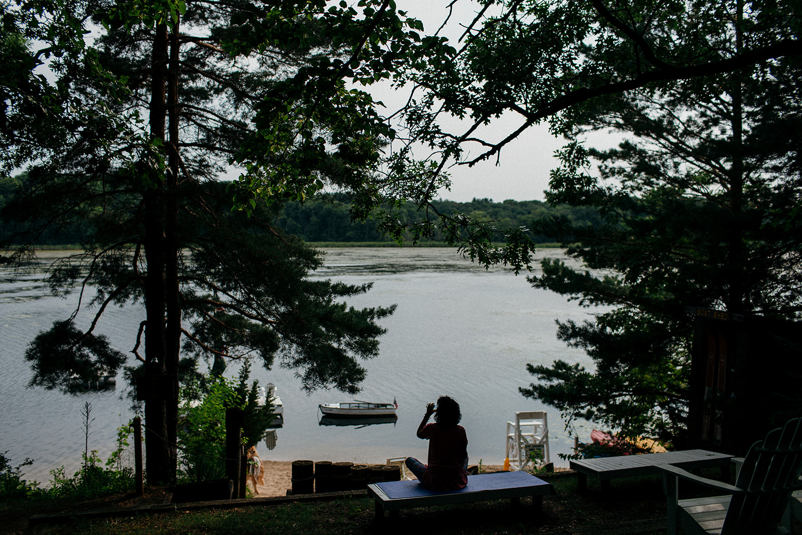 A woman sitting on a yoga mat overlooking Lake Wandawega 