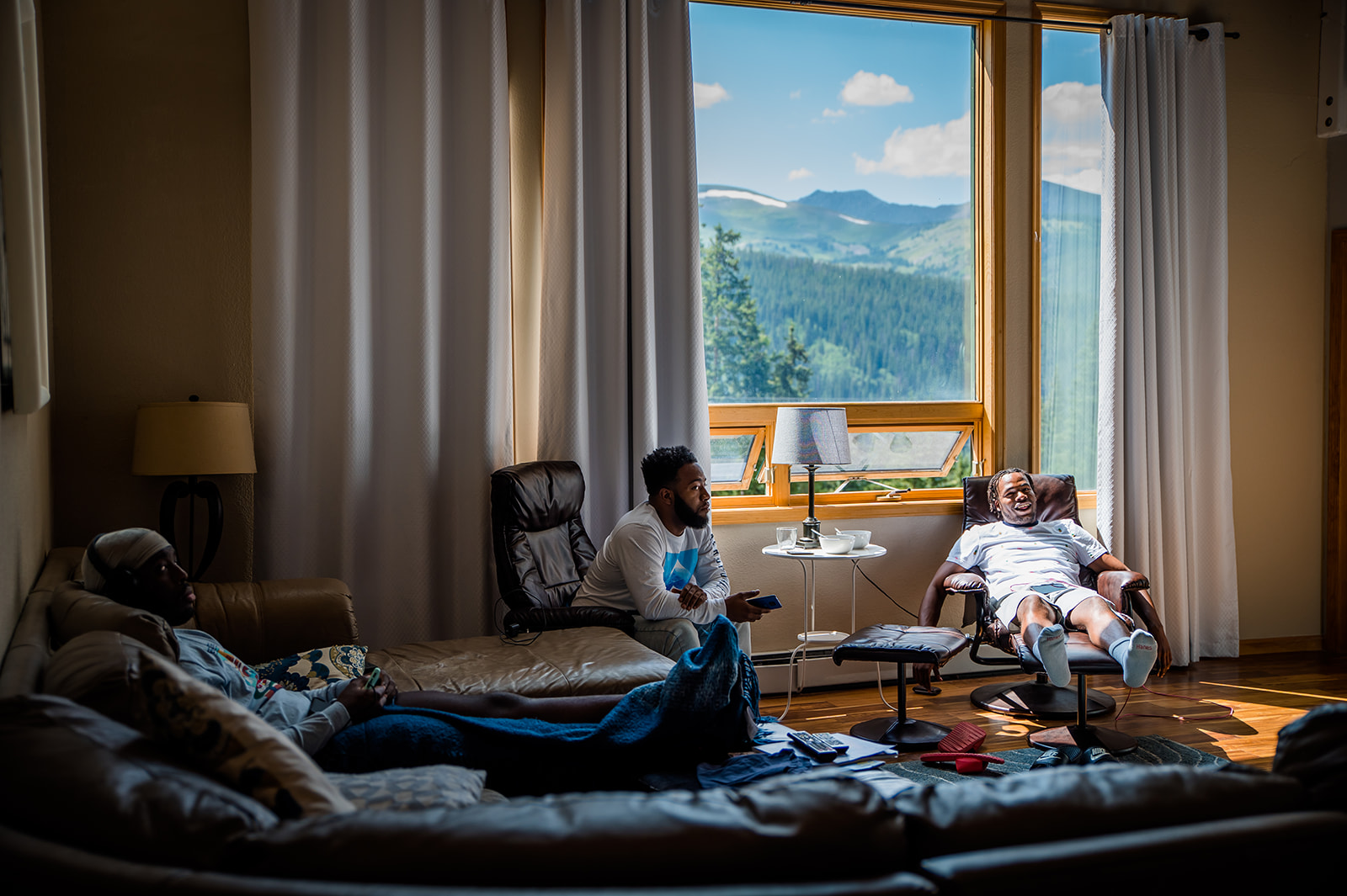 the groom and groomsmen hang on in the mountain cabin before getting ready for his breckenridge elopement 