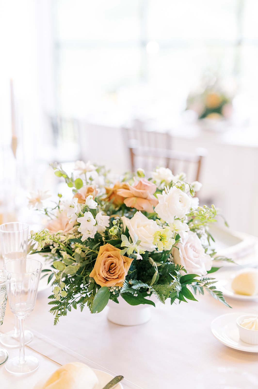 bright summer floral arrangement in cream and orange at  Summer Crossed Keys Estate Wedding by Haley Richter Photography