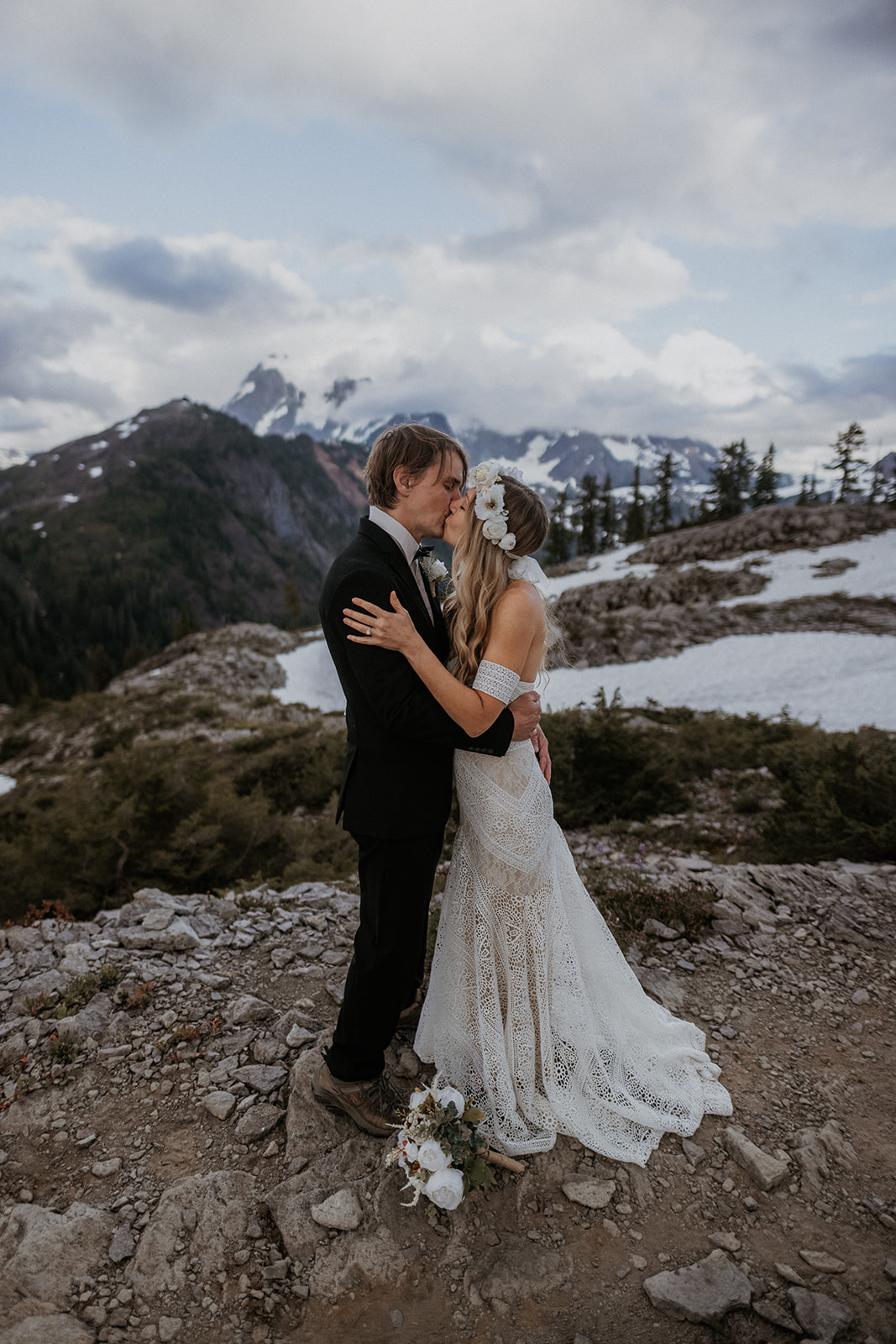 A bride and groom kissing during their boho elopement in North Cascades National Park at Artist Point.