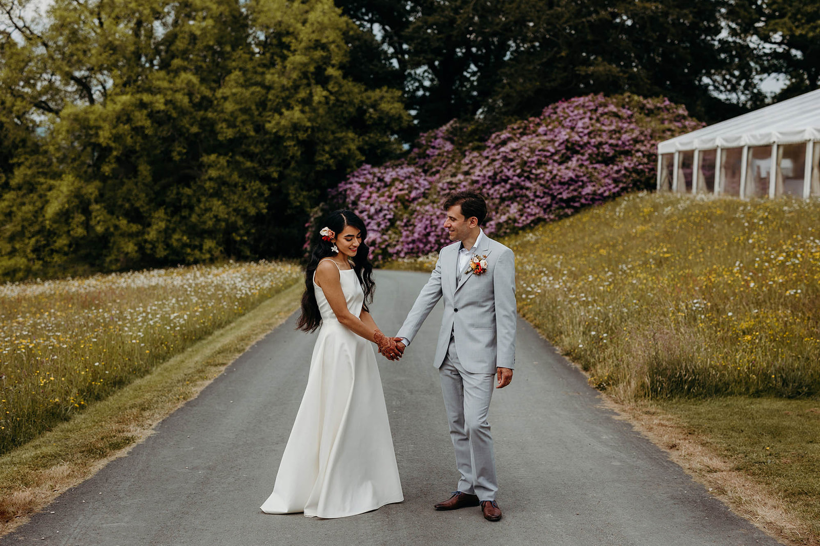 bride and groom hold hands during wedding in Welsh countryside
