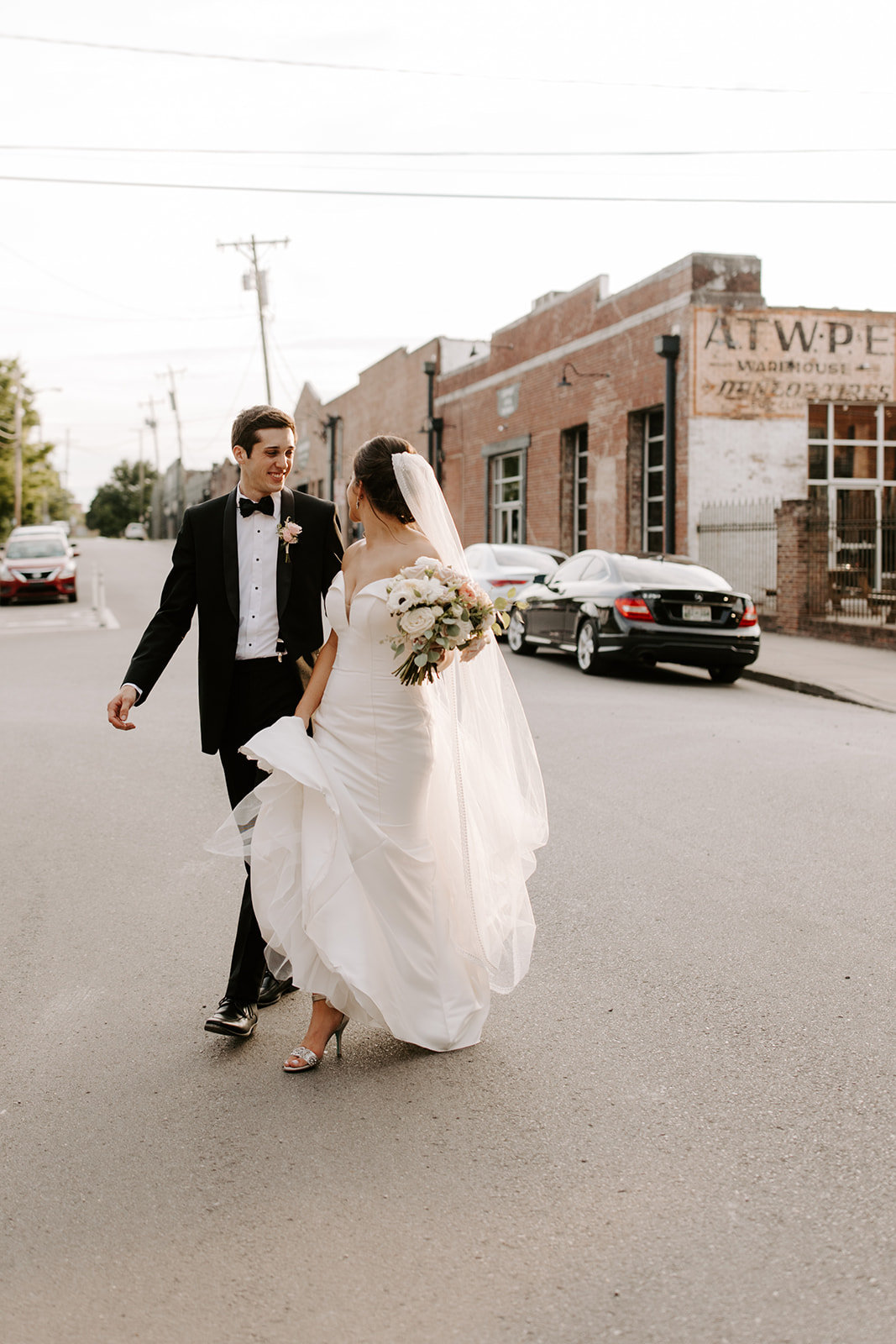 Candid wedding photography of couple crossing the street at Marathon Village, Nashville, Tennessee