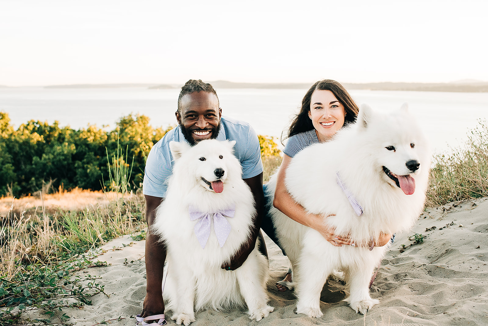 An interracial couple is photographed with their dogs for their engagement session at Discovery Park in Seattle, WA