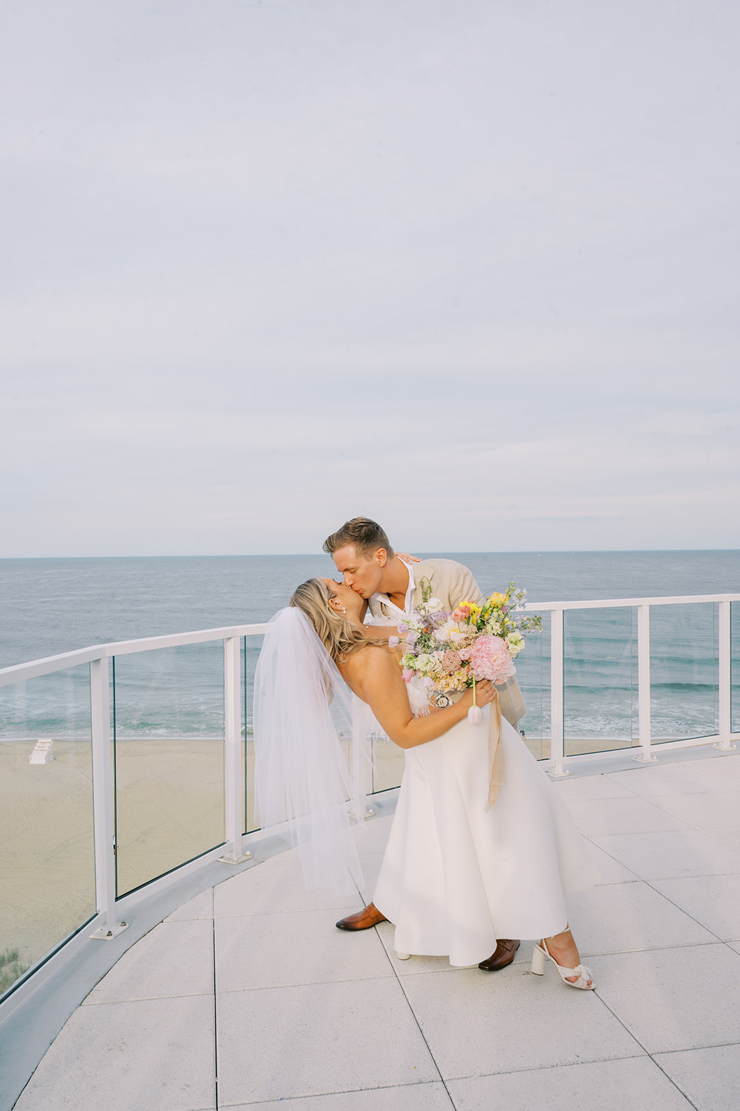 bride and groom kiss Chic and Modern Pastel Rainbow Wedding at the Ocean Front Wave Resort in Long Branch, NJ