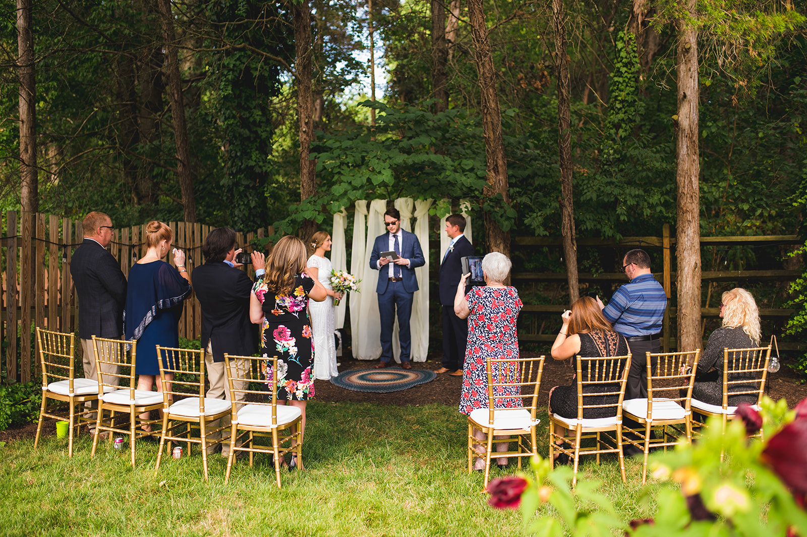 A loving couple exchanging vows during their intimate home elopement ceremony surrounded by immediate family.