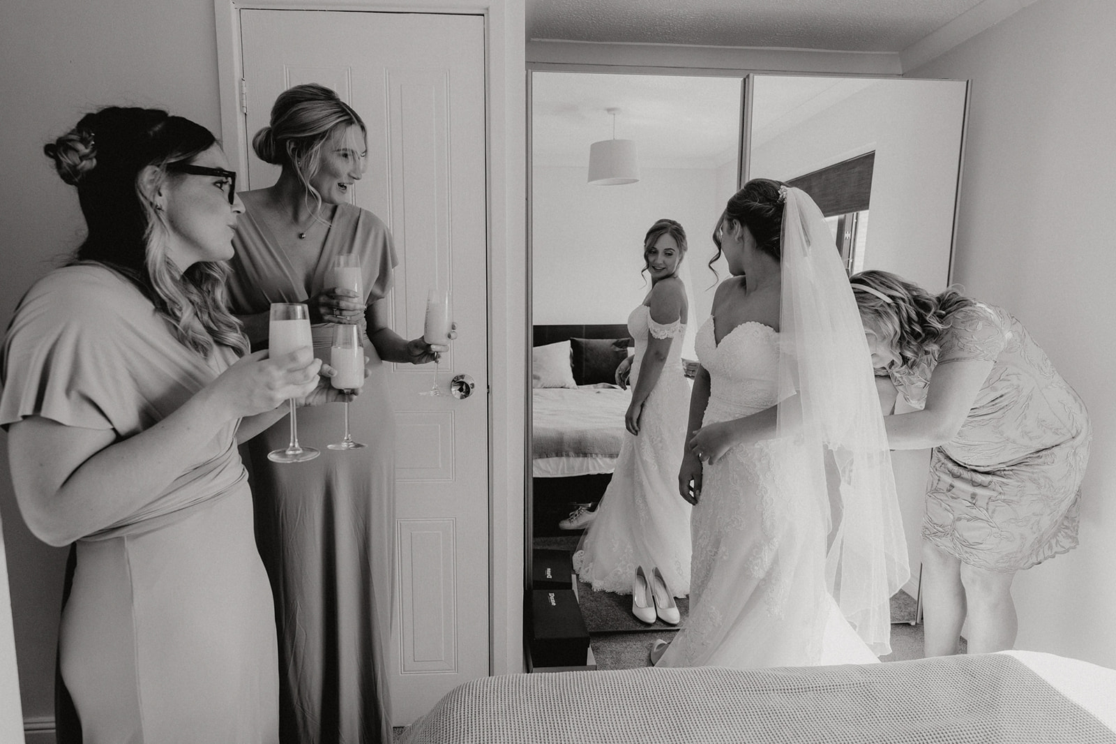 The bride, having a helping hand into her wedding dress