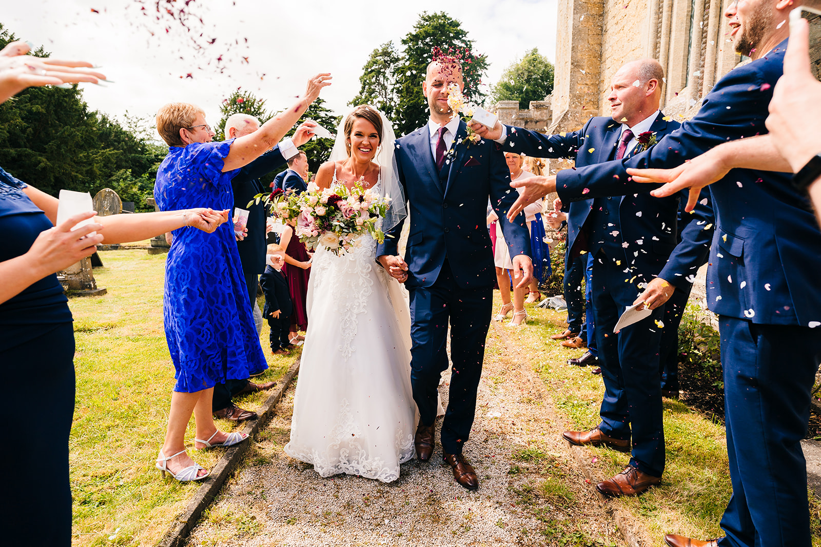 Bride and groom get covered in confetti after their wedding ceremony
