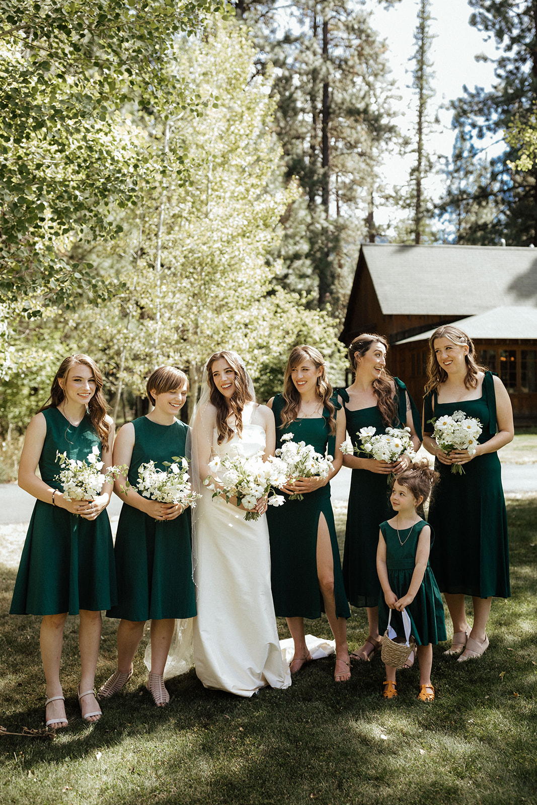 bride and bridesmaids wearing green dresses and laughing at lake creek lodge