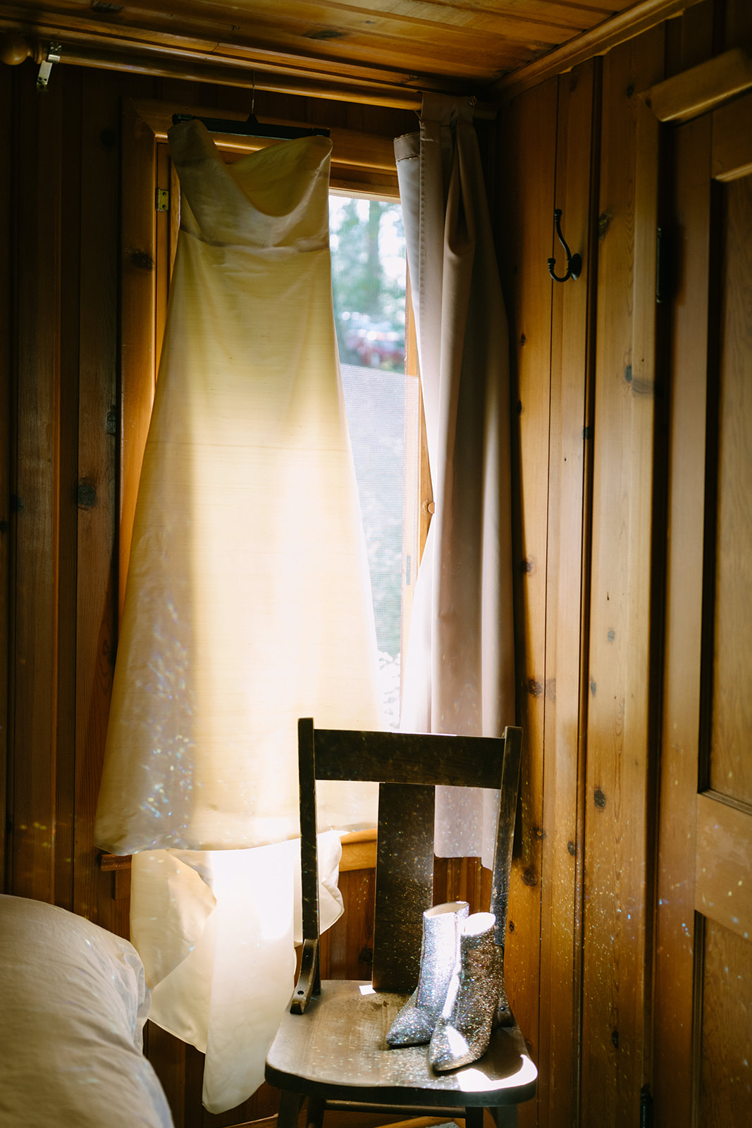 wedding dress and sequin shoes hanging in cabin