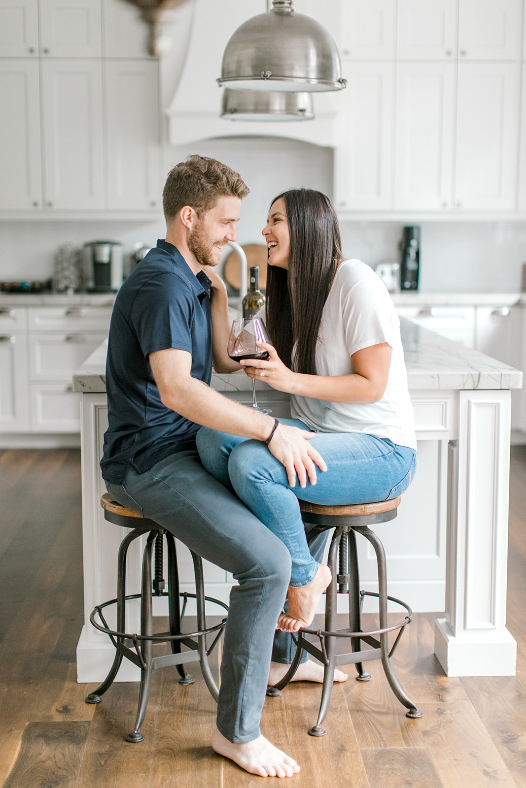 Couple cuddles in their kitchen during their at-home engagement session