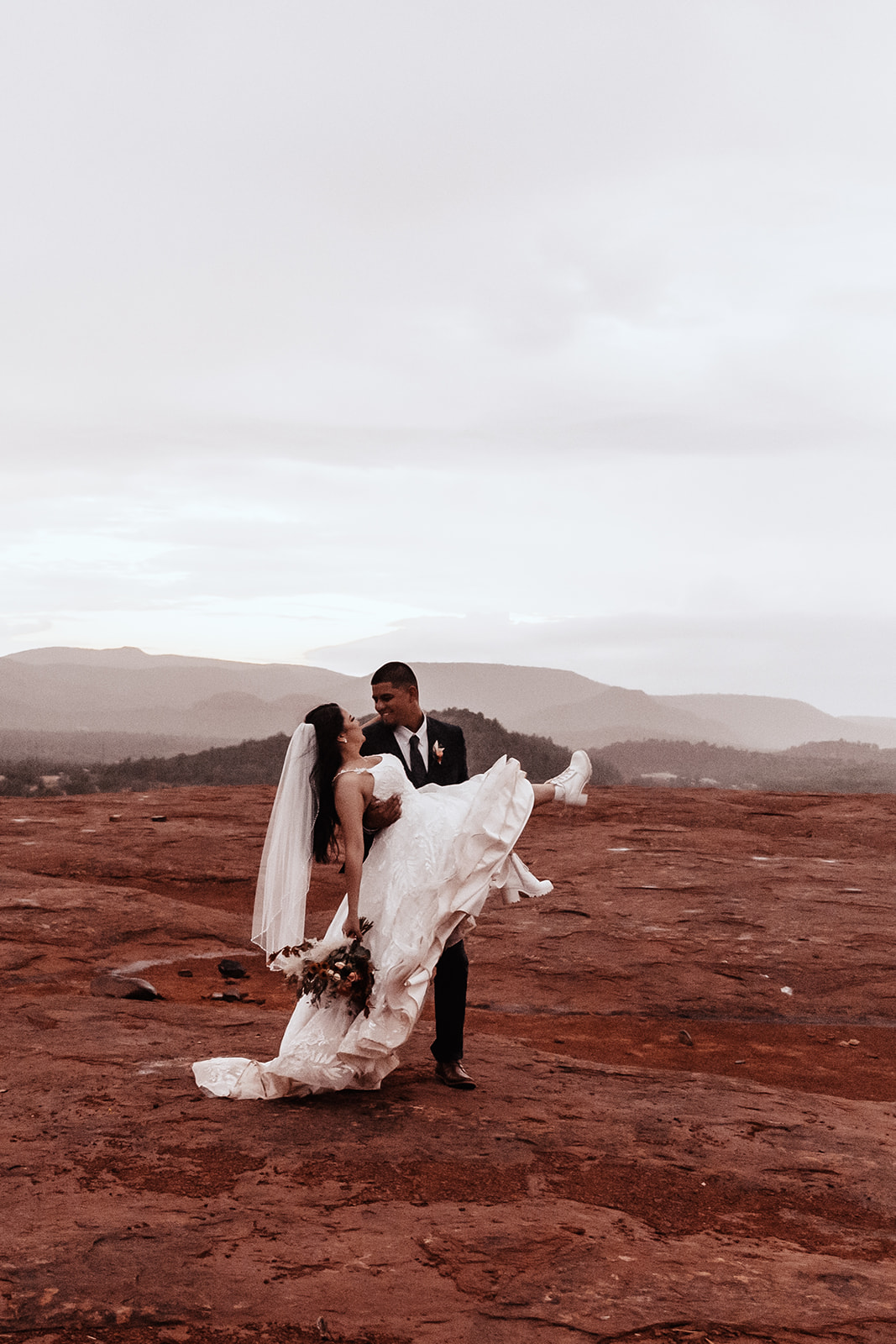A couple who eloped in sedona dance in the rain