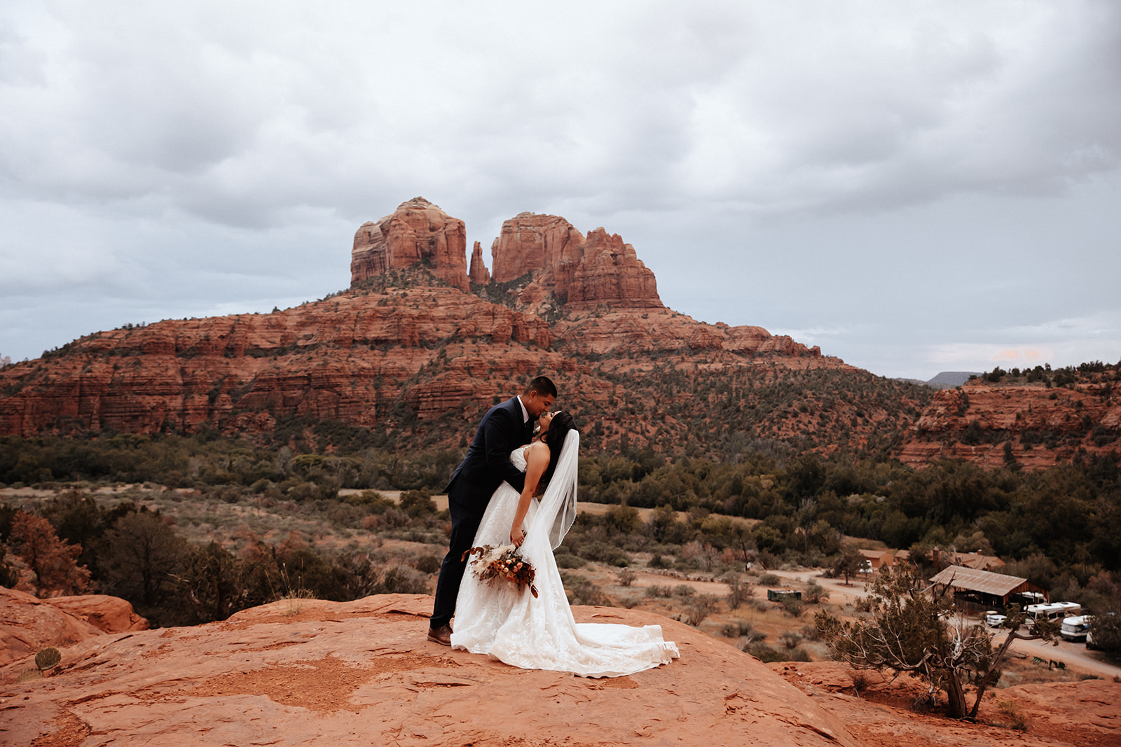 A couple who eloped in sedona kiss in front of red rocks