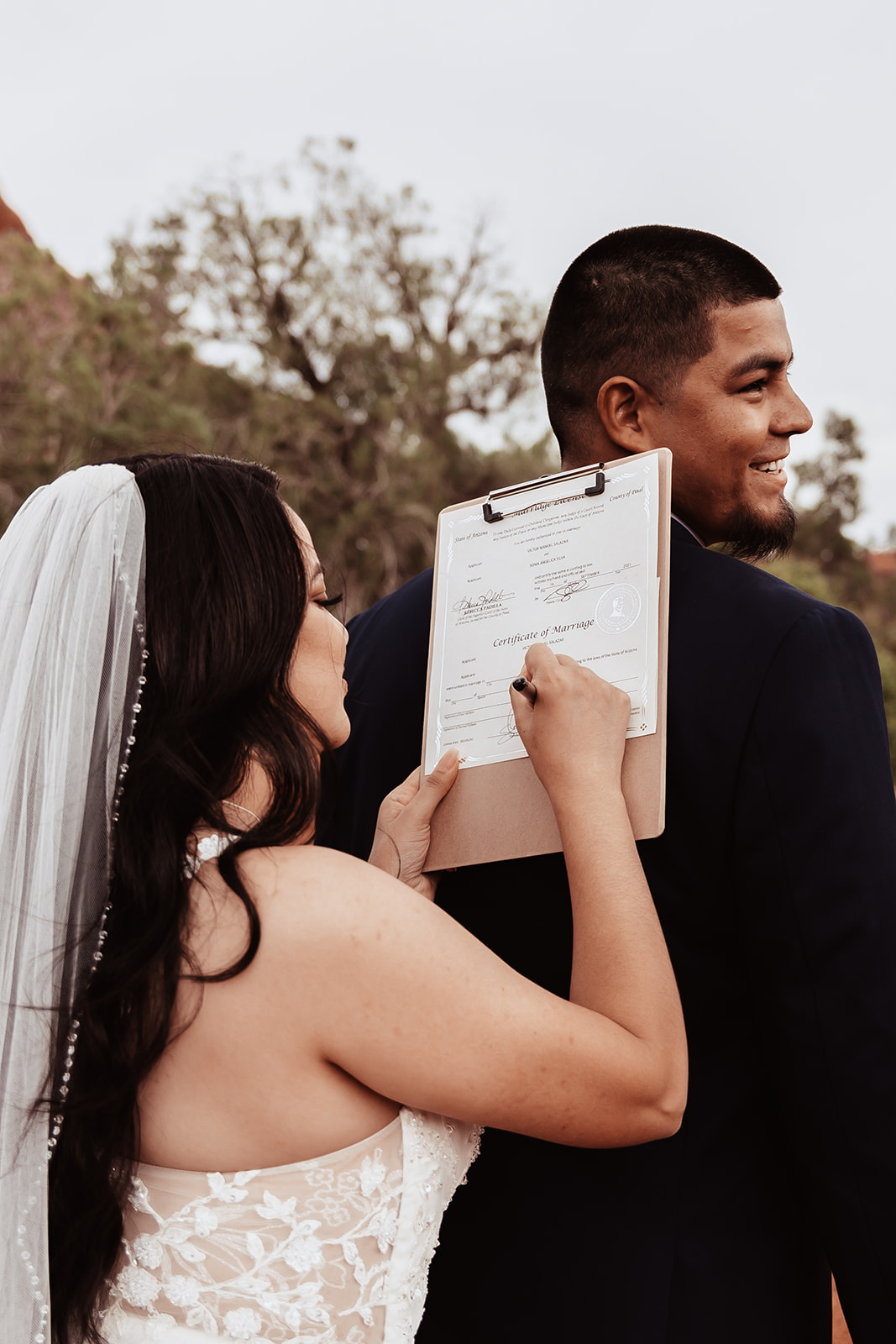 A couple who eloped in sedona sign their marriage license