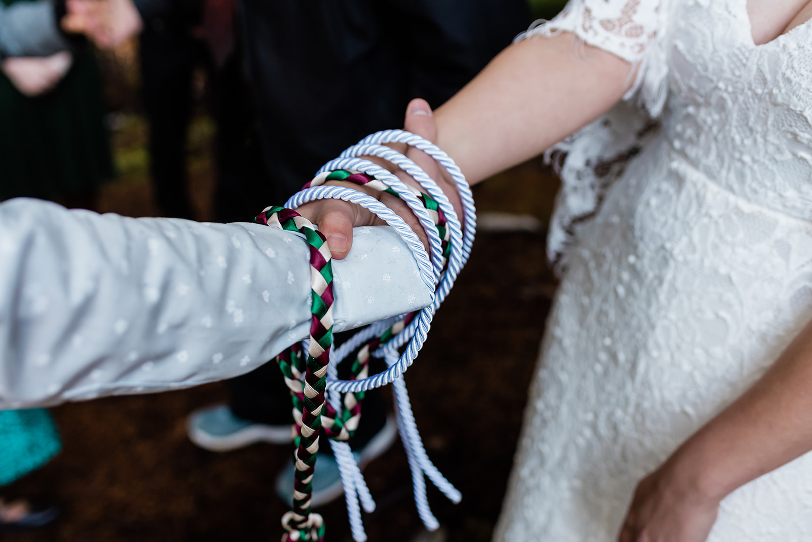 This is a picture taken during an elopement ceremony. It is the bride and groom during a knotting ceremony.