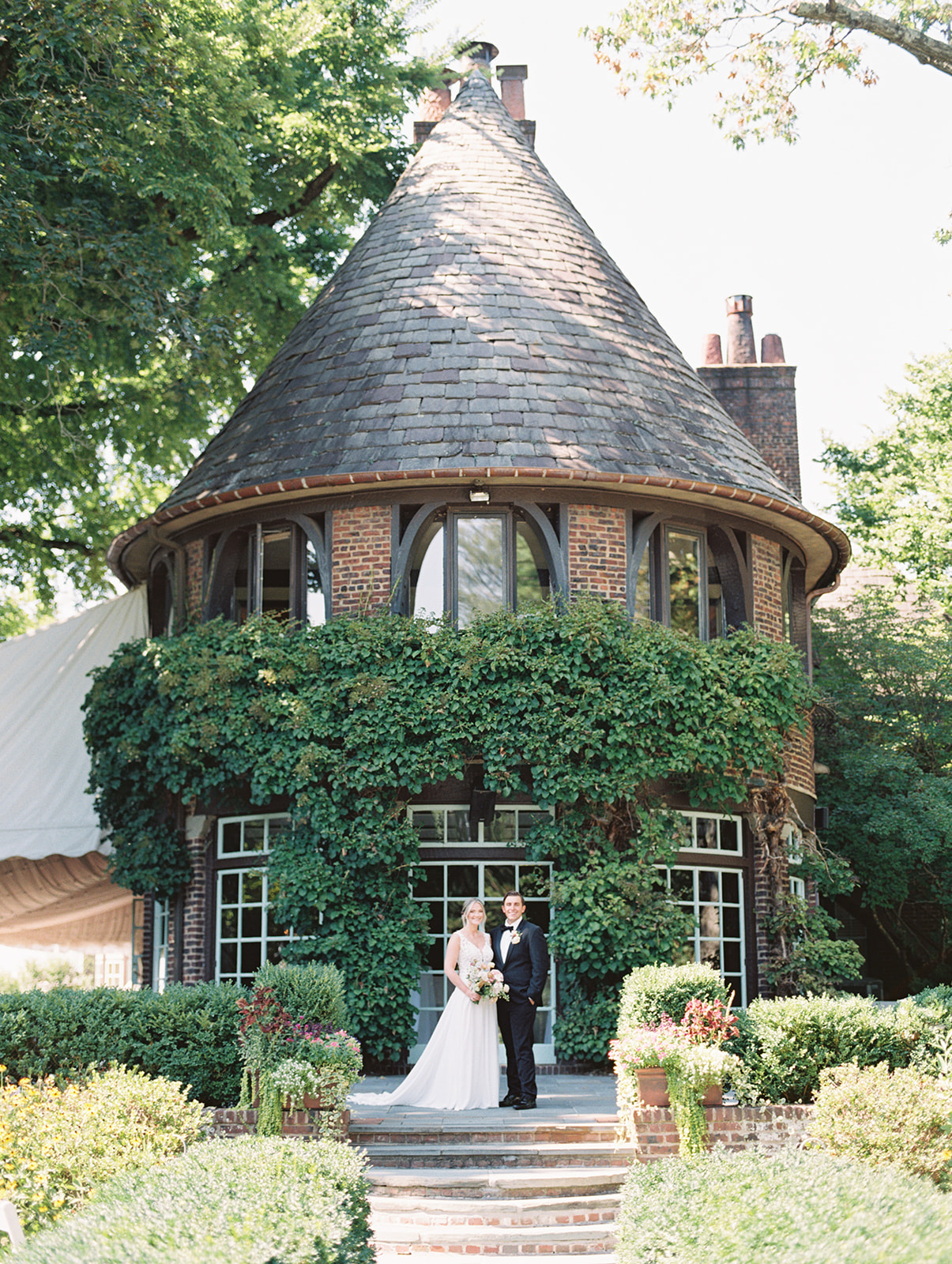 bride and groom stand at the base of garden house for Greenville Country Club wedding