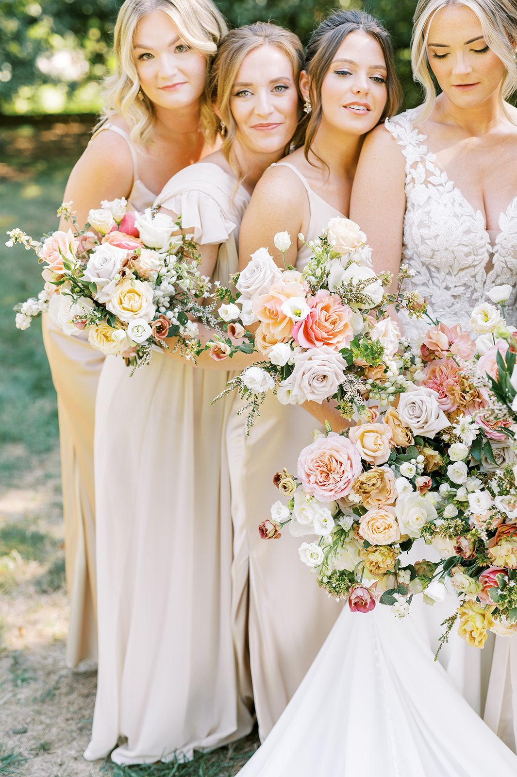 luxury moment of bridesmaids champagne dresses huddled together with lush pink autumn bouquets greenville country club