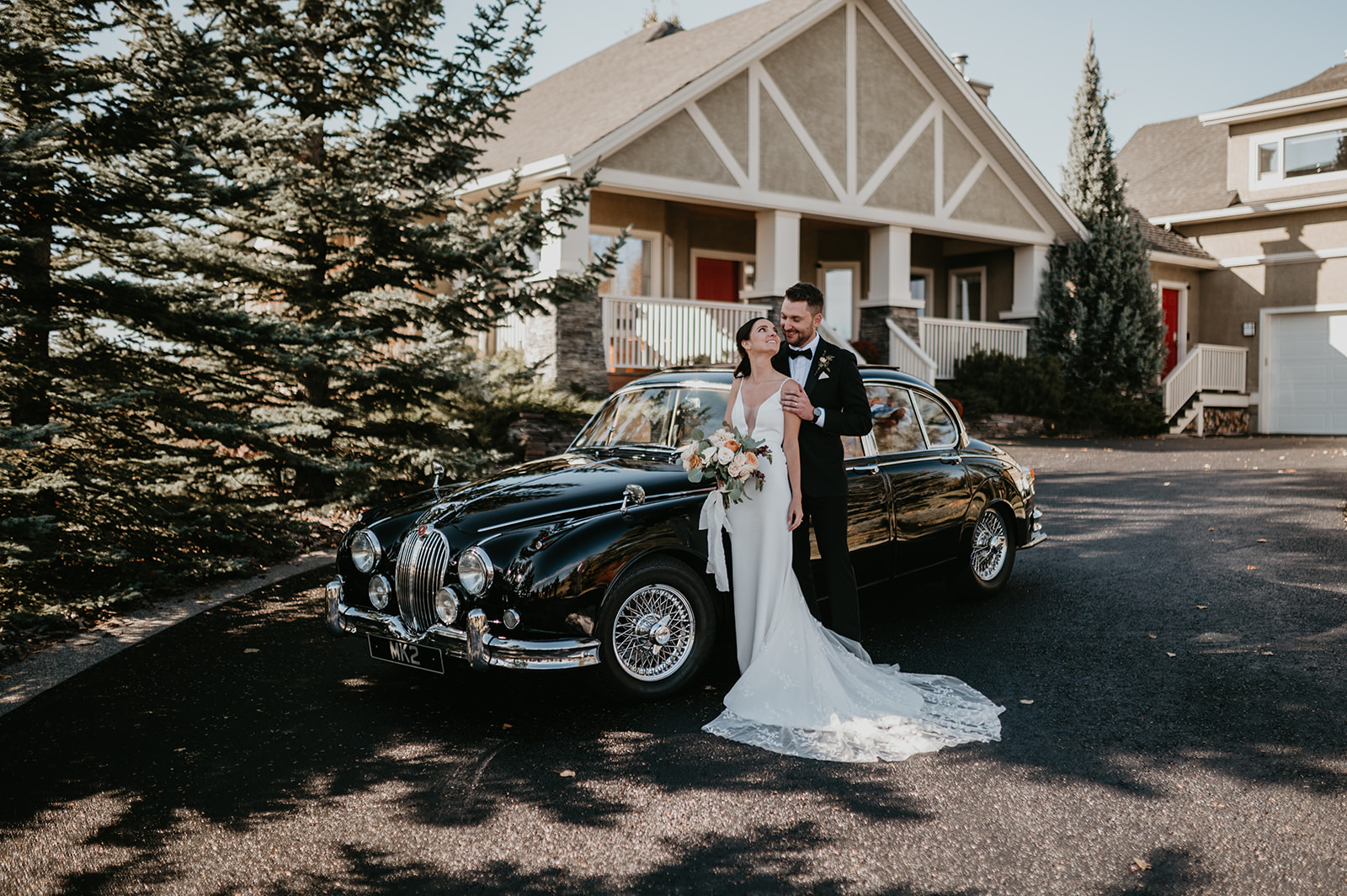 a bride and groom in a vintage Jaguar 