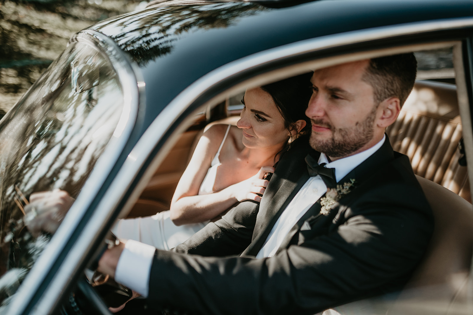 a bride and groom in a vintage Jaguar 